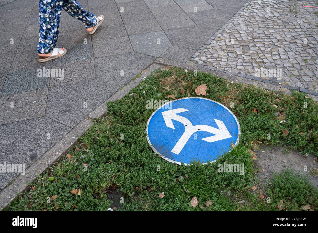 02.09.2024, Germania, , Berlino - Europa - Una passeggiata pedonale oltrepassa un cartello con le frecce di direzione sul Kurfuerstendamm nella città Ovest. 0SL240902D Foto Stock