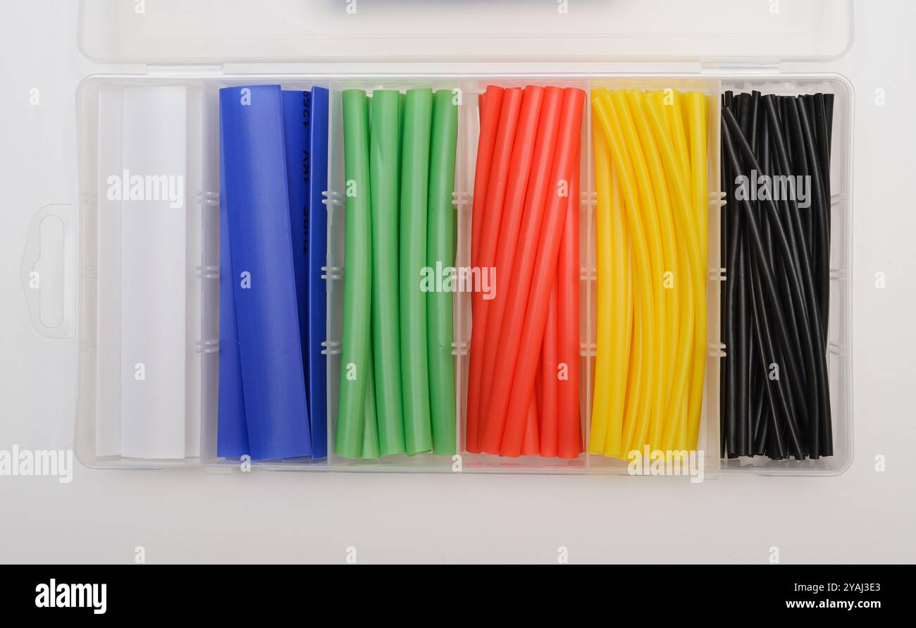 Questa immagine mostra un contenitore in plastica organizzato che contiene una varietà di guaine termorestringenti in diversi colori. Ogni scomparto contiene una guaina termorestringente Foto Stock