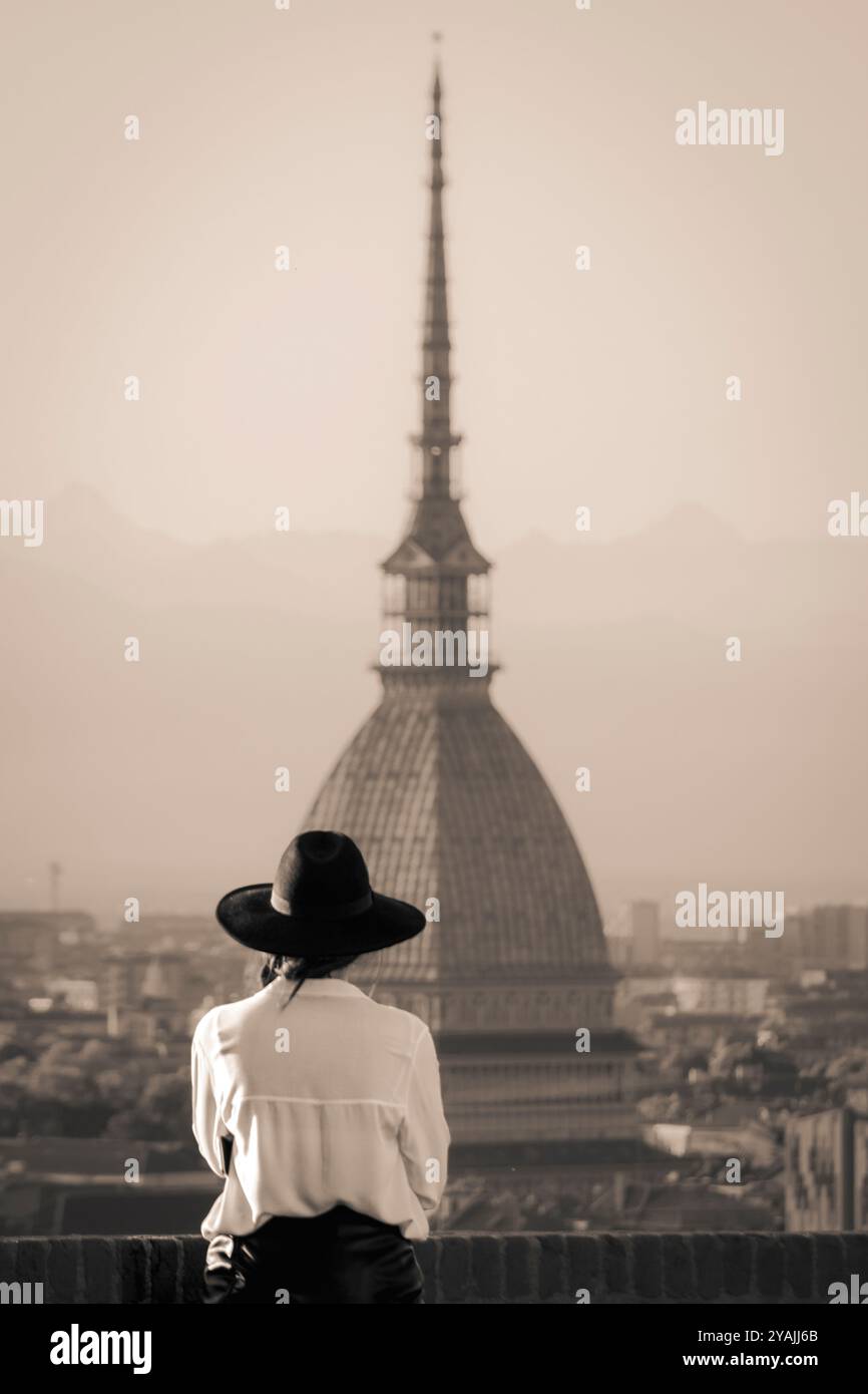 L'iconica Mole Antonelliana in vista dalla terrazza del Monte dei Cappuccini. Una ragazza con un cappello sta guardando il panorama. Foto Stock