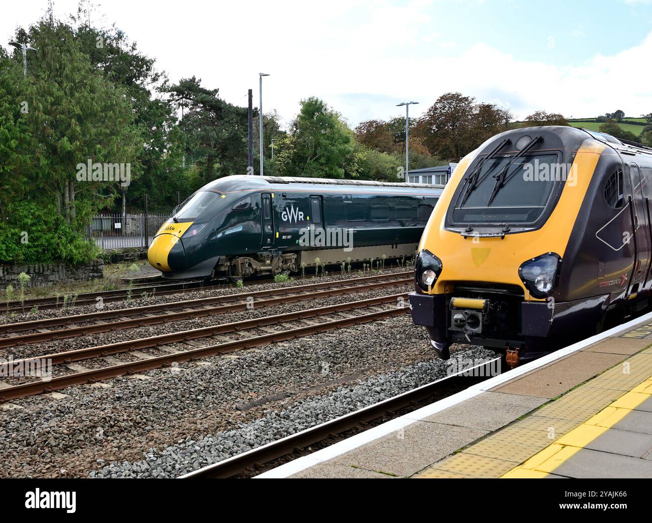 Treno CrossCountry 1S49 il 11,27 da Plymouth a Edimburgo aspetta di lasciare Totnes diretto con un'auto a motore n. 220024, mentre arriva un treno Intercity Express. Foto Stock