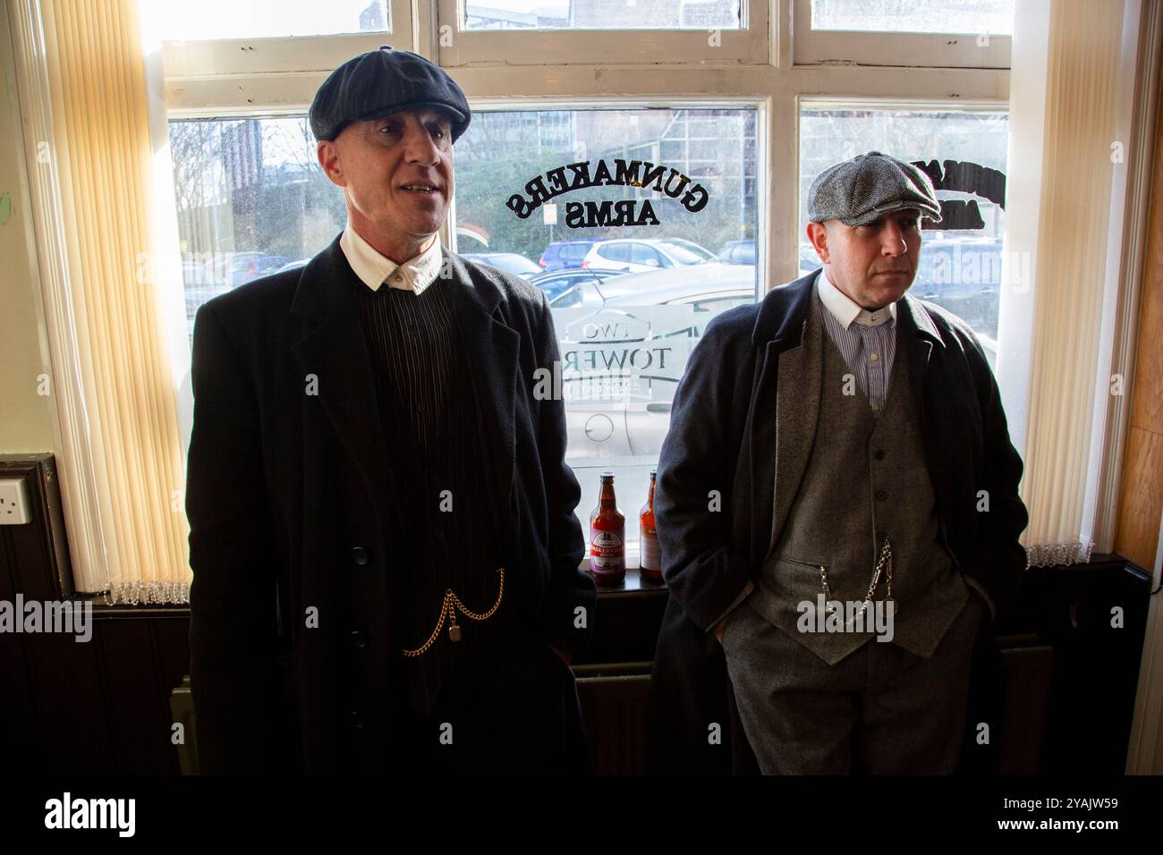 Personaggi all'interno del pub Gunmakers Arms vestito da Peaky Blinders il 13 gennaio 2017 a Birmingham, Regno Unito. Il Gun Quarter è un quartiere della città di Birmingham, Inghilterra, che è stato per molti anni un centro dell'industria mondiale della produzione di armi, specializzata nella produzione di armi da fuoco militari e armi sportive. È un'area industriale a nord del centro città. Foto Stock