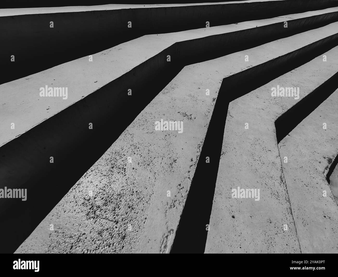Armonizzare luce e ombra. Contrasto simmetrico nelle scale in cemento per esterni. Bianco e nero, monocromatico. Foto Stock