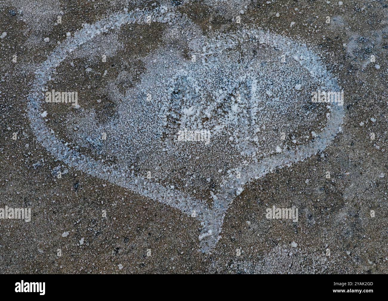 Frozen Love: Lettera "M" racchiusa in Snowy Heart su pavimento in cemento Foto Stock