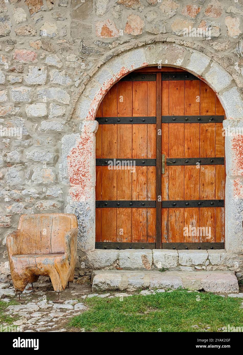 Fascino rustico: Porta chiusa in legno di colore marrone chiaro con sfondo in pietra Foto Stock