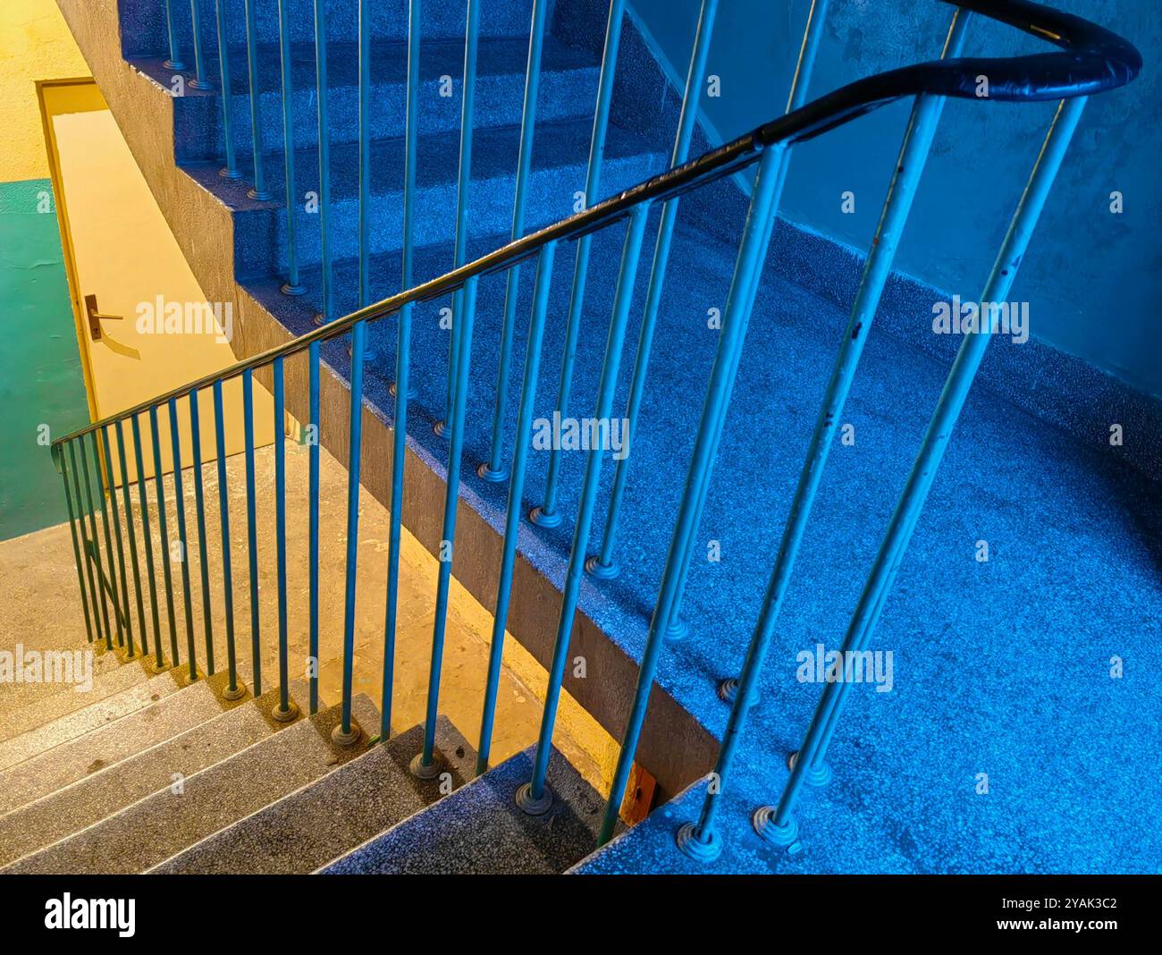 Freddo e calore. Colori contrastanti negli interni dell'edificio con le scale. Foto Stock