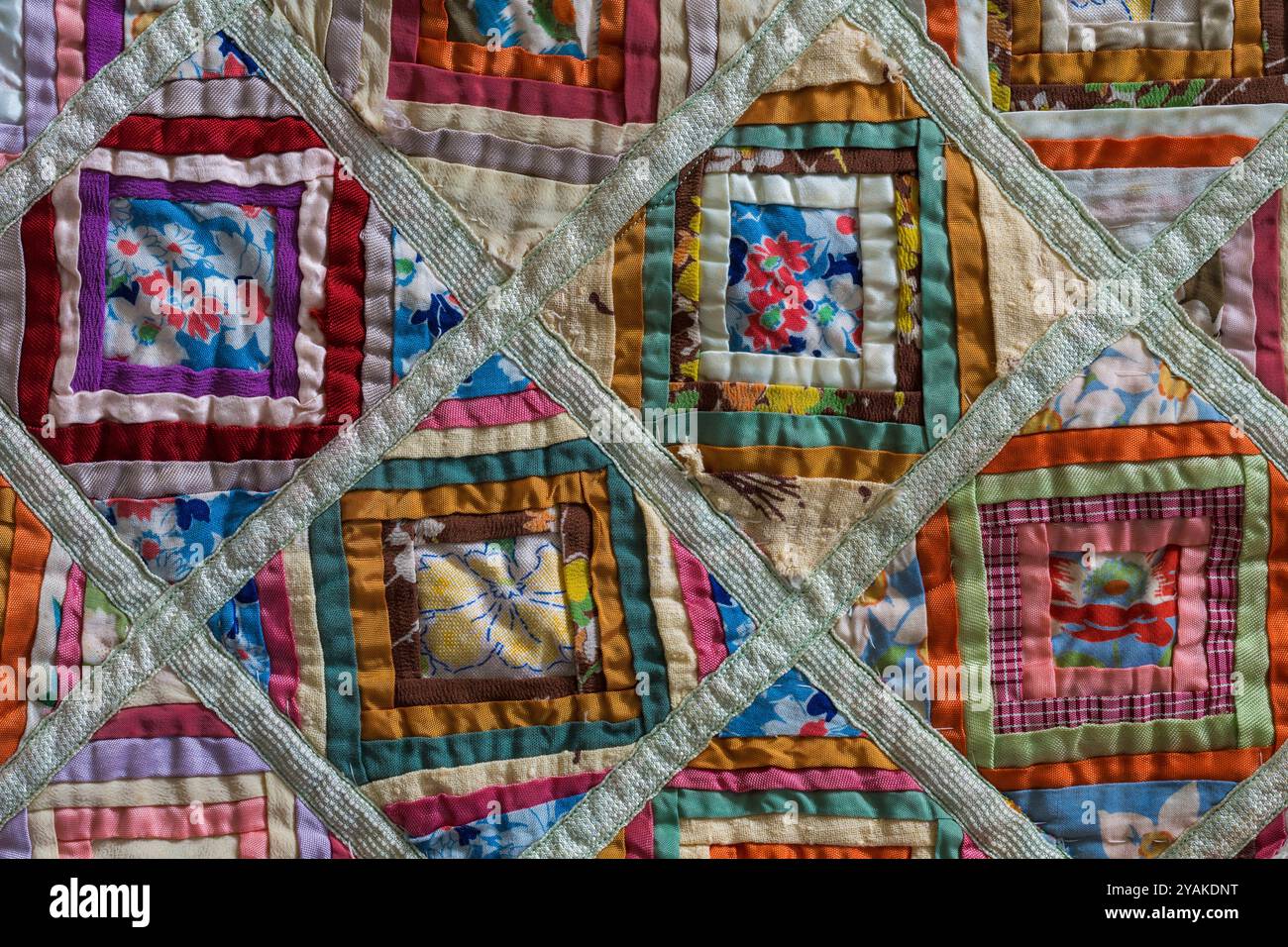 Dettaglio ravvicinato di una vecchia trapunta in patchwork vintage: Campioni di tessuto patchwork, pezzi di tessuto cuciti insieme Foto Stock