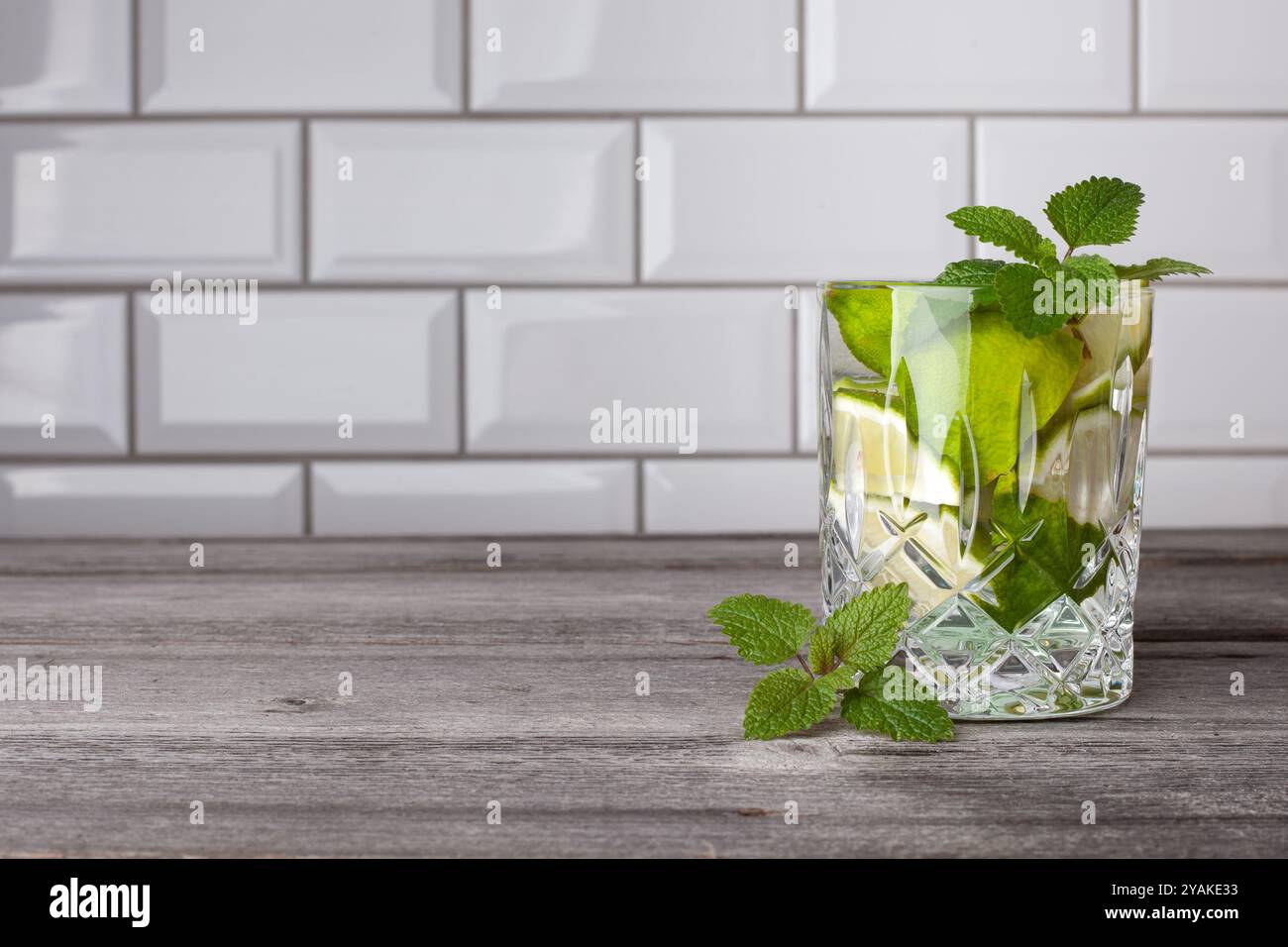 Cocktail Caipirinha originale in piedi sul lato destro dell'immagine. Spazio libero per il testo. Gustoso cocktail con menta, rum, lime, zucchero e ghiaccio. Foto Stock