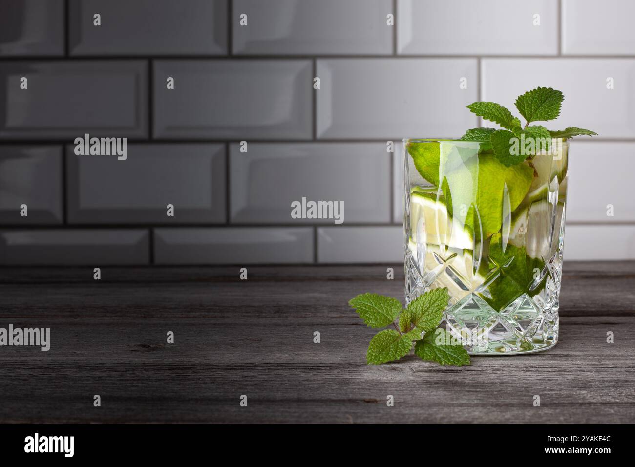 Cocktail Caipirinha originale in piedi sul lato destro dell'immagine. Spazio libero per il testo. Gustoso cocktail con menta, rum, lime, zucchero e ghiaccio. Foto Stock