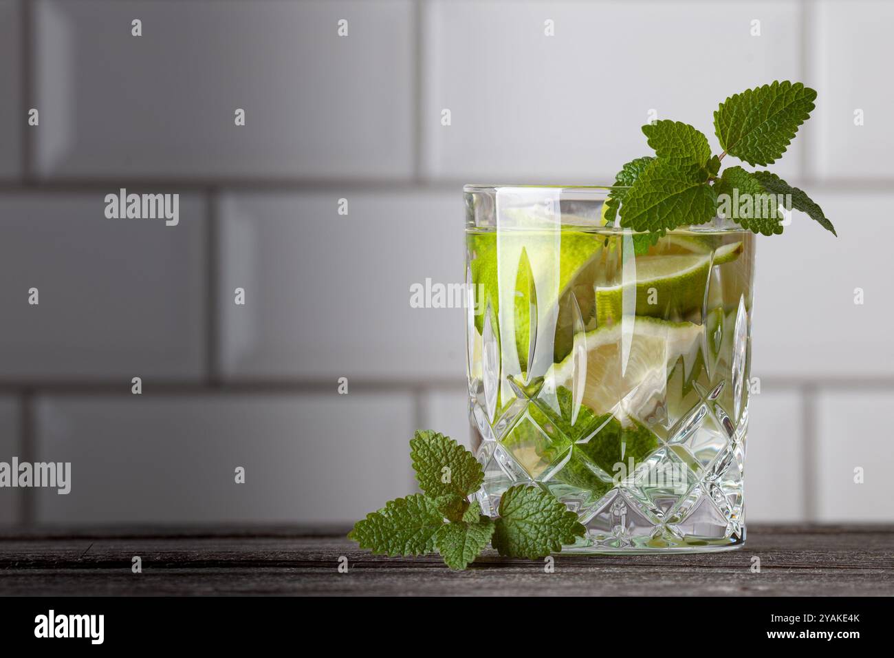 Cocktail Caipirinha originale in piedi sul lato destro dell'immagine. Spazio libero per il testo. Gustoso cocktail con menta, rum, lime, zucchero e ghiaccio. Foto Stock