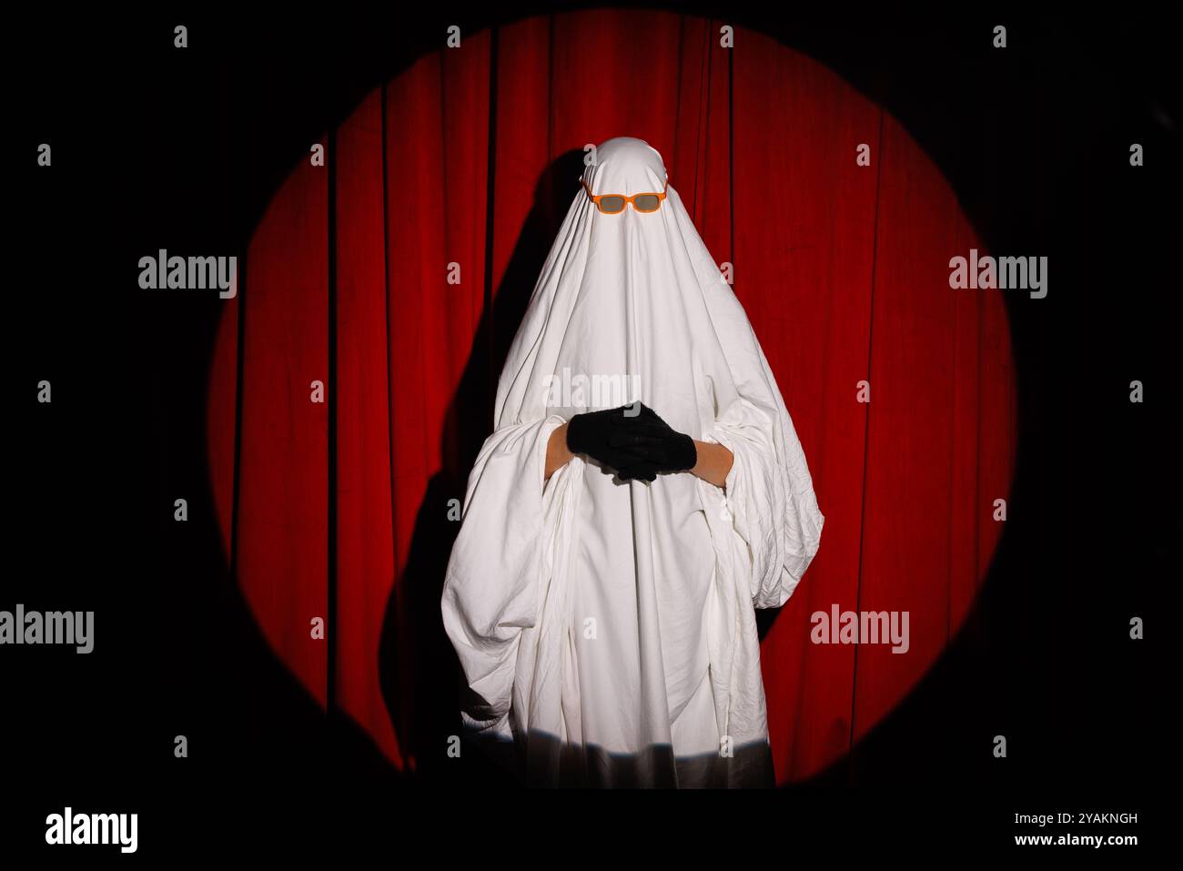 Buon Halloween. Simpatico fantasma su sfondo arancione brillante. Vestiario fantasma, festa di Halloween carnevale. Fantasma adorabile, concetto di Halloween Foto Stock