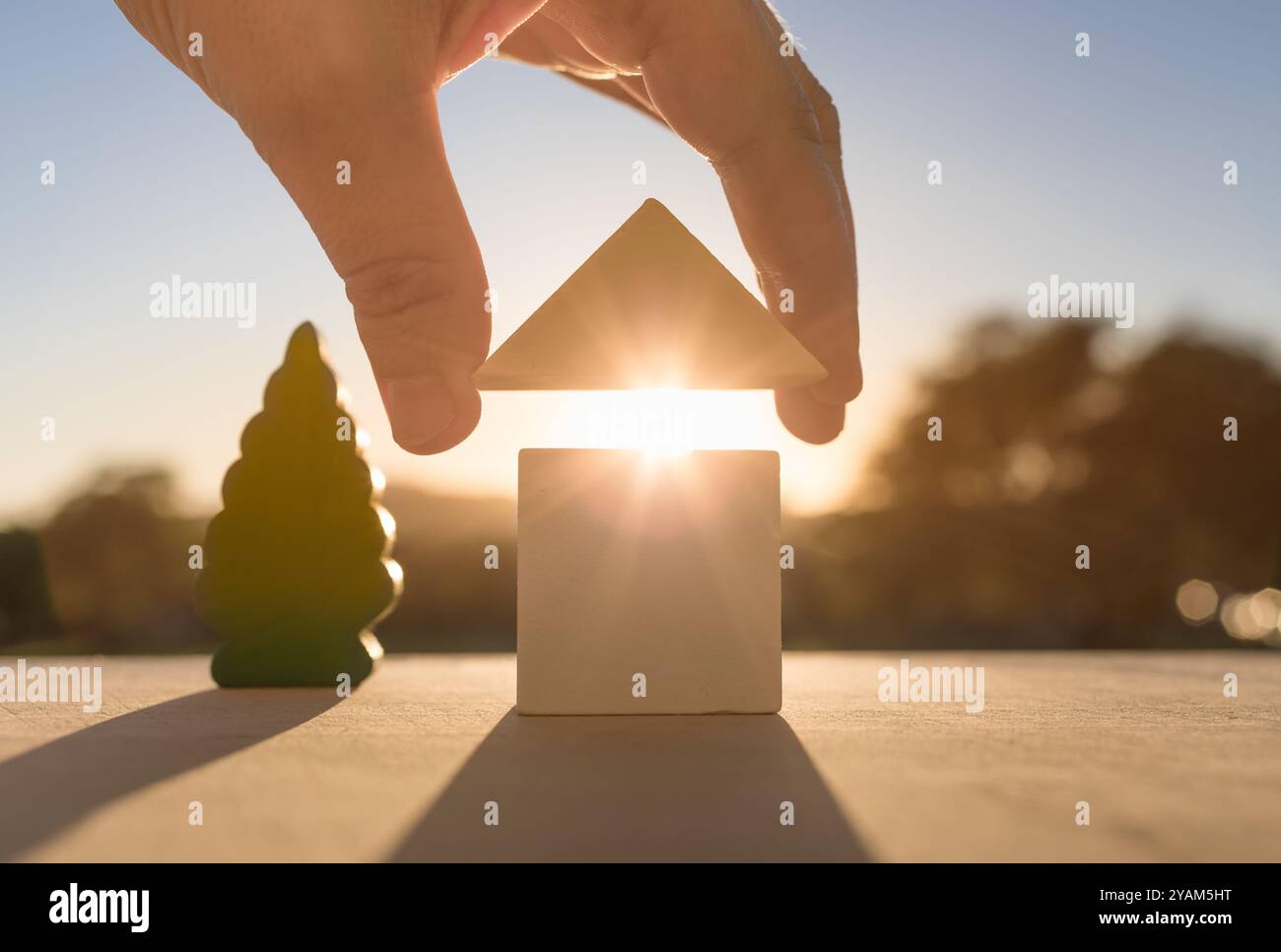 Uomo che costruisce una casa a partire dai blocchi. Immobili, comprare, vendere immobili. Foto Stock