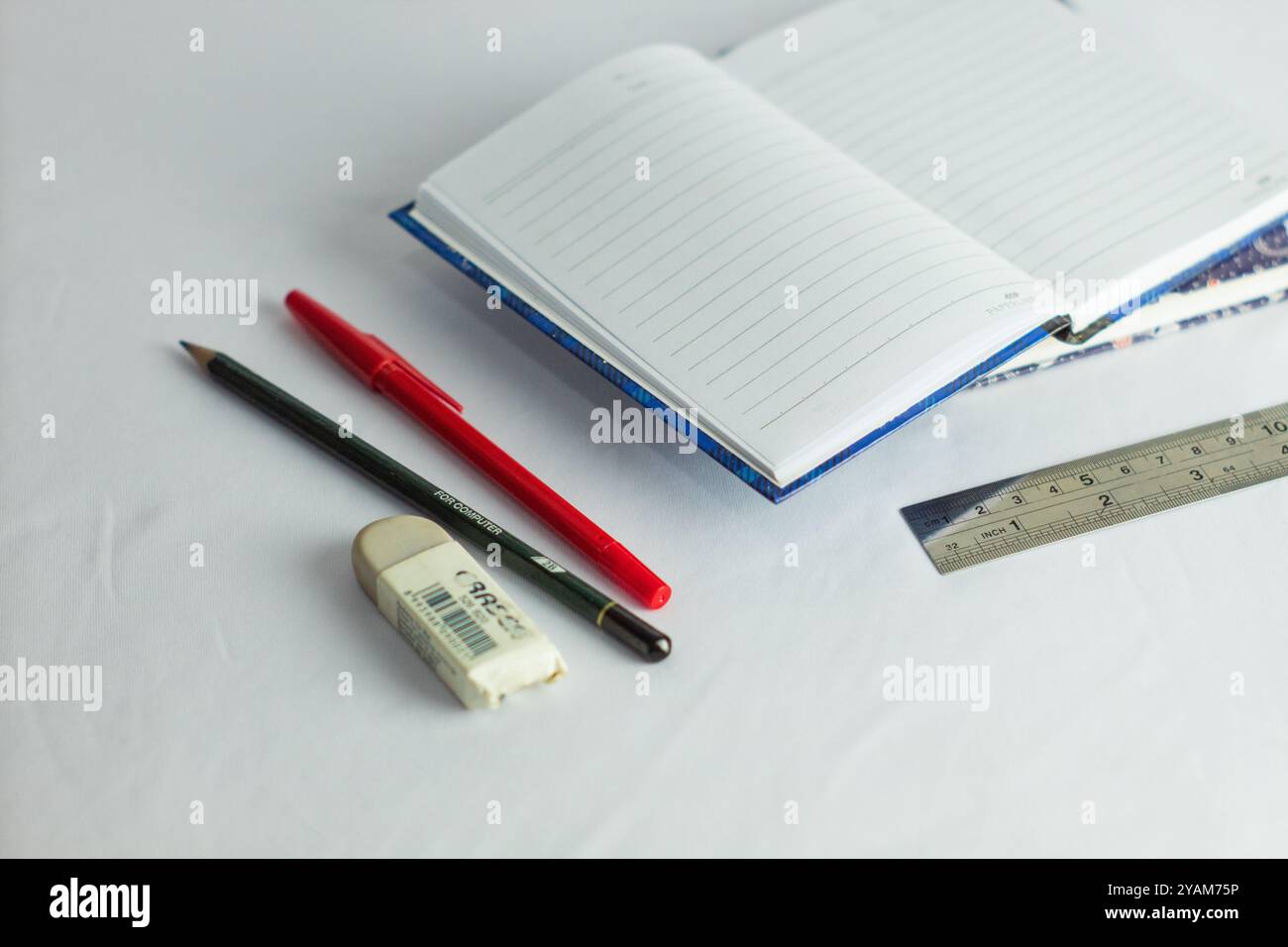 Indonesia 9 settembre 2024, quaderno con altra cancelleria in foto ravvicinata da un angolo laterale su sfondo bianco isolato Foto Stock