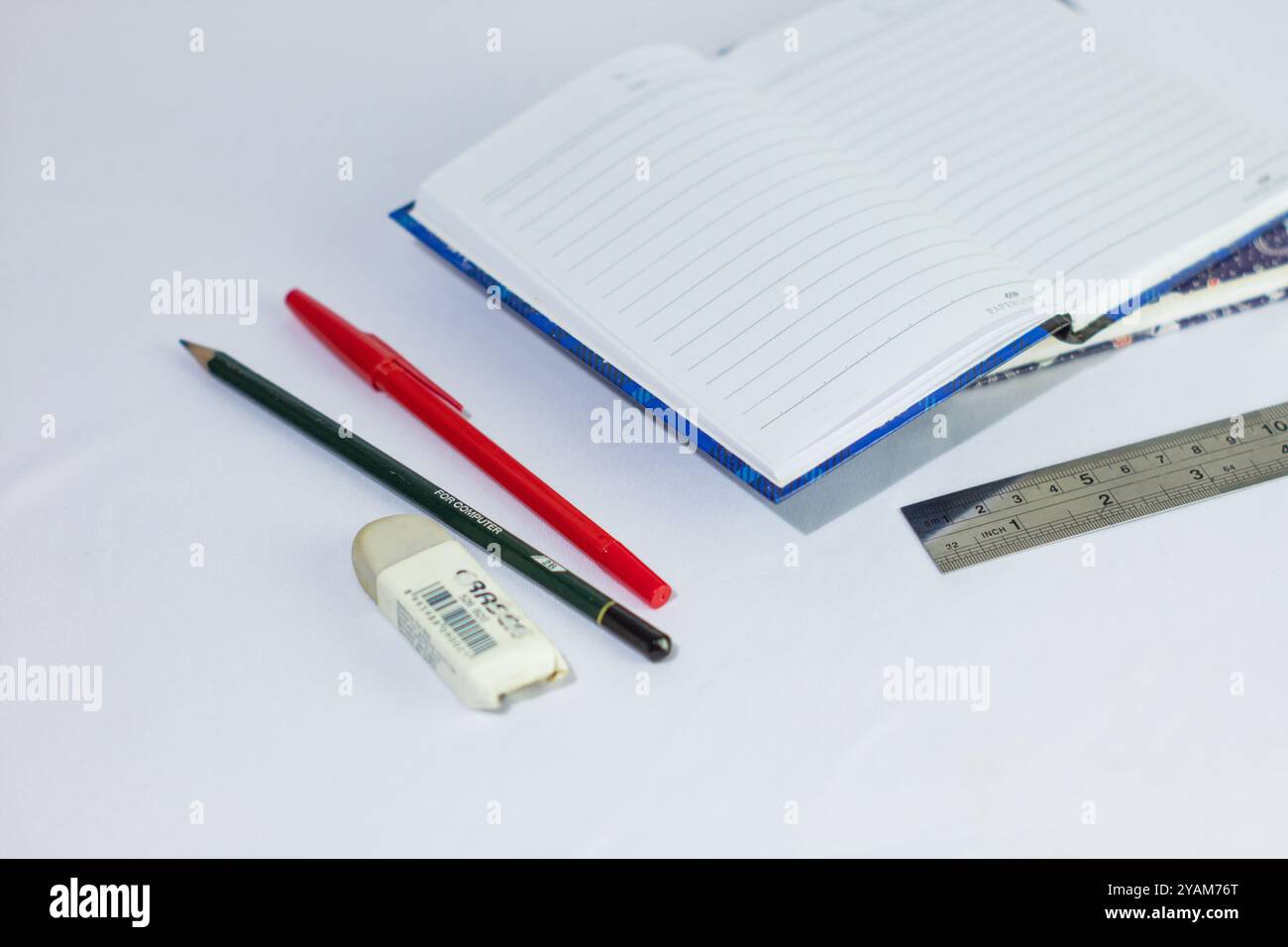 Indonesia 9 settembre 2024, quaderno con altra cancelleria in foto ravvicinata da un angolo laterale su sfondo bianco isolato Foto Stock
