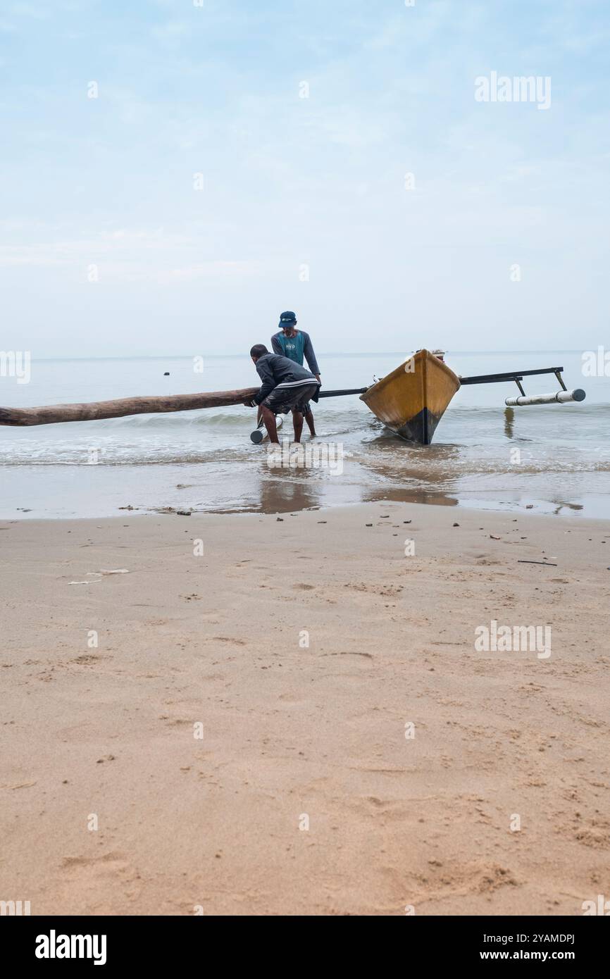 Due pescatori stanno preparando la loro barca sulla riva prima di navigare Foto Stock