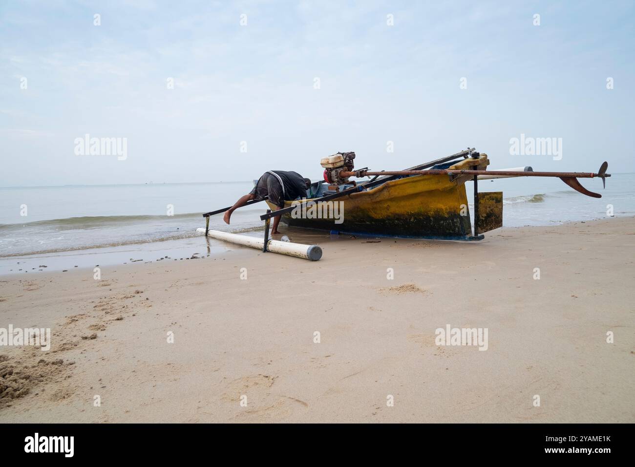 Due pescatori stanno preparando la loro barca sulla riva prima di navigare Foto Stock
