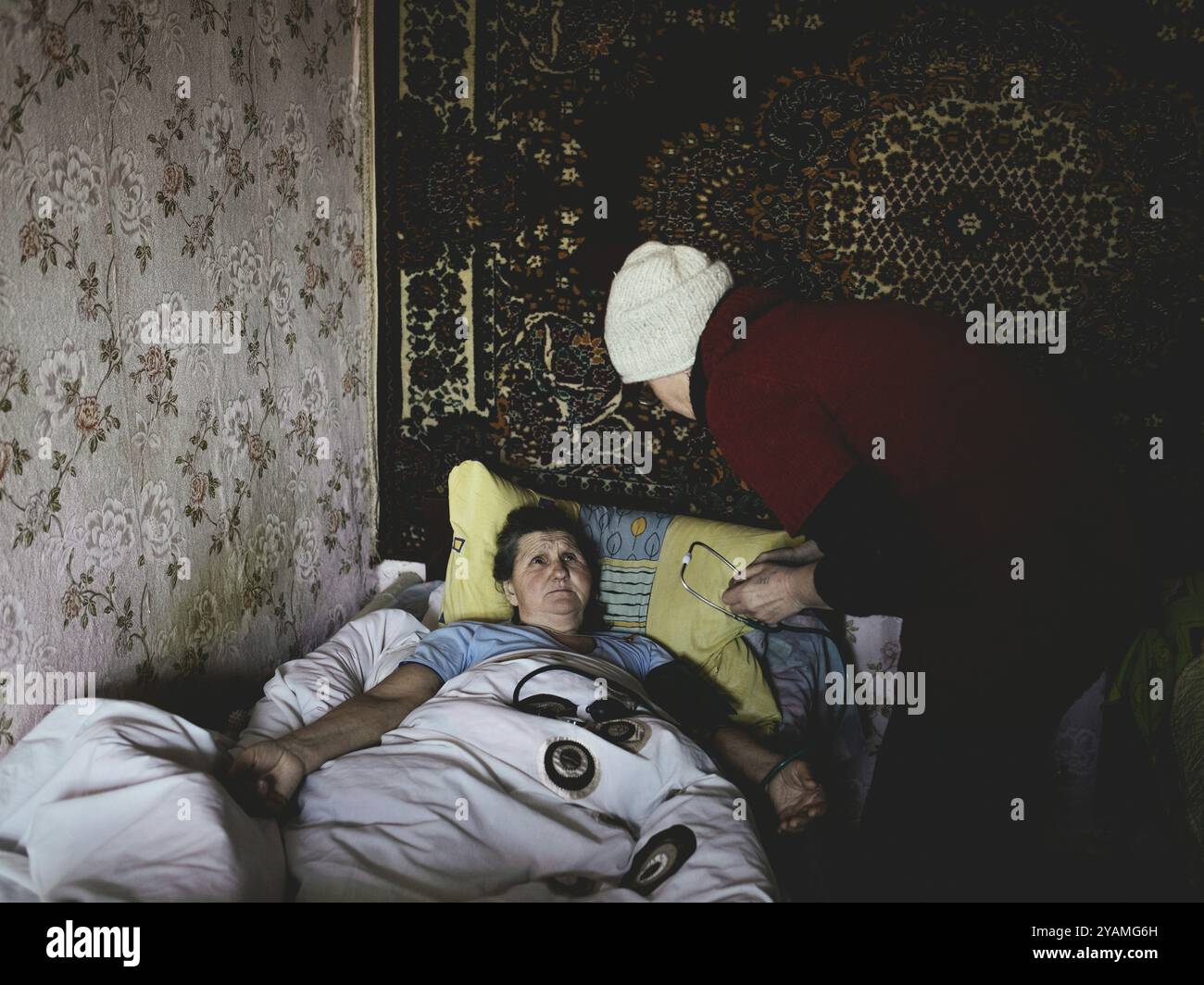 Tryohizbenka, Ucraina, Lilia Schwez in visita a Valentina, 75 anni, al mattino ci sono state diverse esplosioni di granate, ha avuto palpitazioni e alto b Foto Stock
