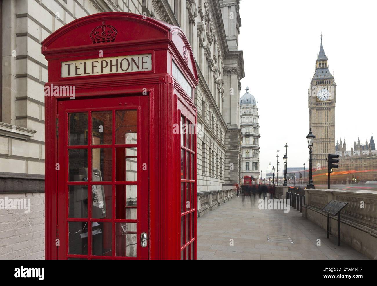 Tradizionale telefono rosso a Londra, un simbolo della città. Frammento di cabine con il Big Ben sullo sfondo della serata Foto Stock