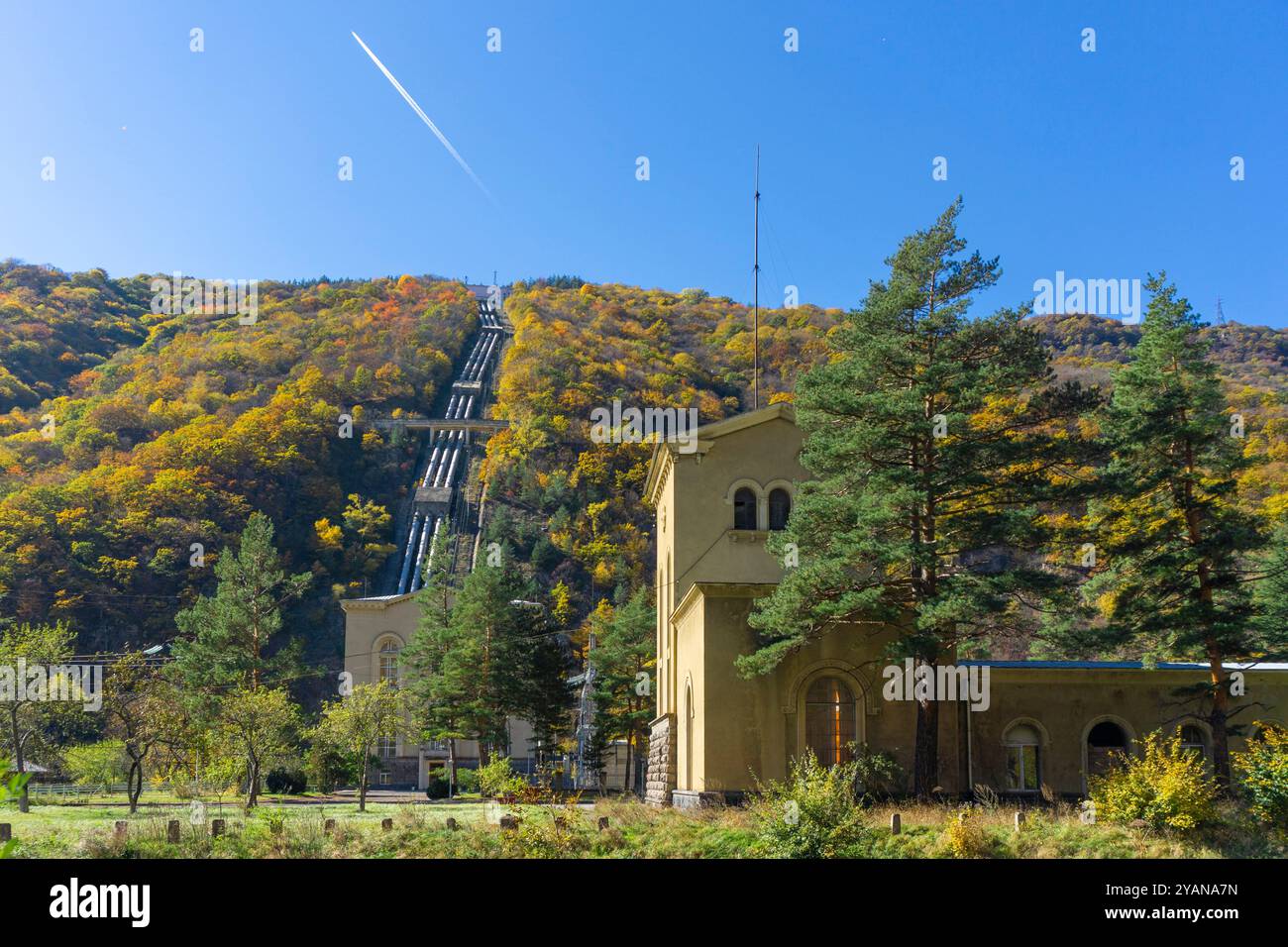 Enormi tubi scendono dalla montagna fino alla centrale idroelettrica nella gola del fiume Khrami circondata da montagne e rocce. Col. Dorato Foto Stock