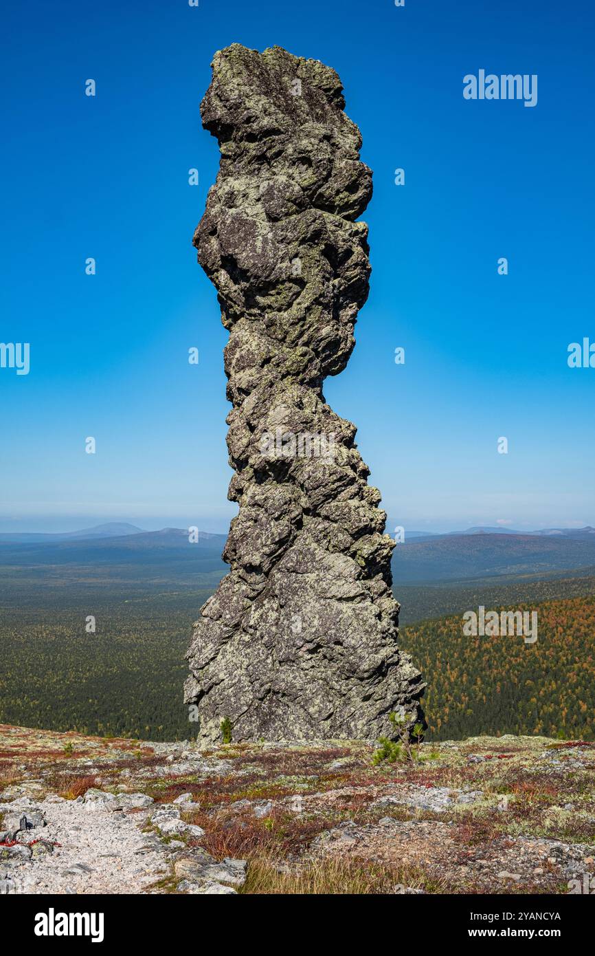 L'uomo si erge orgogliosamente su una cima di una montagna nella regione degli urali in russia, osservando una valle mozzafiato in una giornata di sole. Perfetto per gli amanti della natura Foto Stock