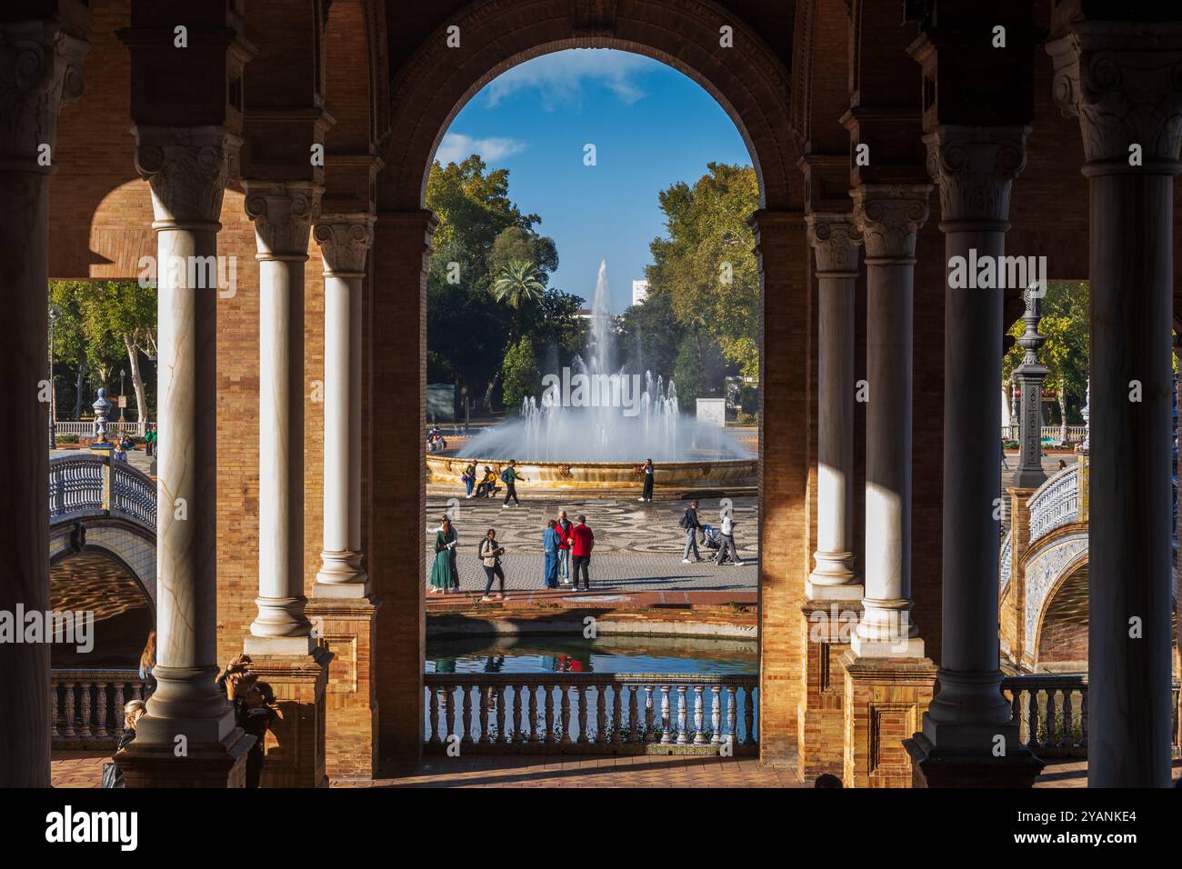 Siviglia, Andalusia, Spagna - 24 ottobre 2023 - Fontana e gente in Plaza de Espana nel Parco Maria Luisa, vista dal centro del padiglione principale Foto Stock