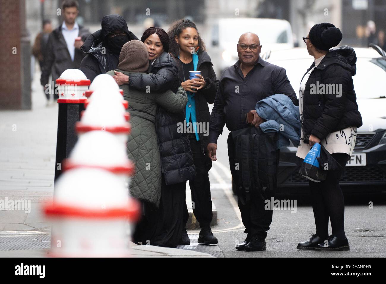 Helen Lumuanganu, la madre di Chris Kaba, abbraccia gli amici insieme a Prosper Kaba (il secondo da destra), padre di Chris Kaba fuori dalla Old Bailey, nel centro di Londra, dove l'ufficiale d'arma da fuoco della Metropolitan Police Martyn Blake è accusato dell'omicidio di Chris nel sud di Londra il 6 settembre 2022. Il signor Kaba è morto dopo essere stato colpito una volta alla testa attraverso il parabrezza di un'auto Audi a Kirstall Gardens, Streatham. Data foto: Martedì 15 ottobre 2024. Foto Stock