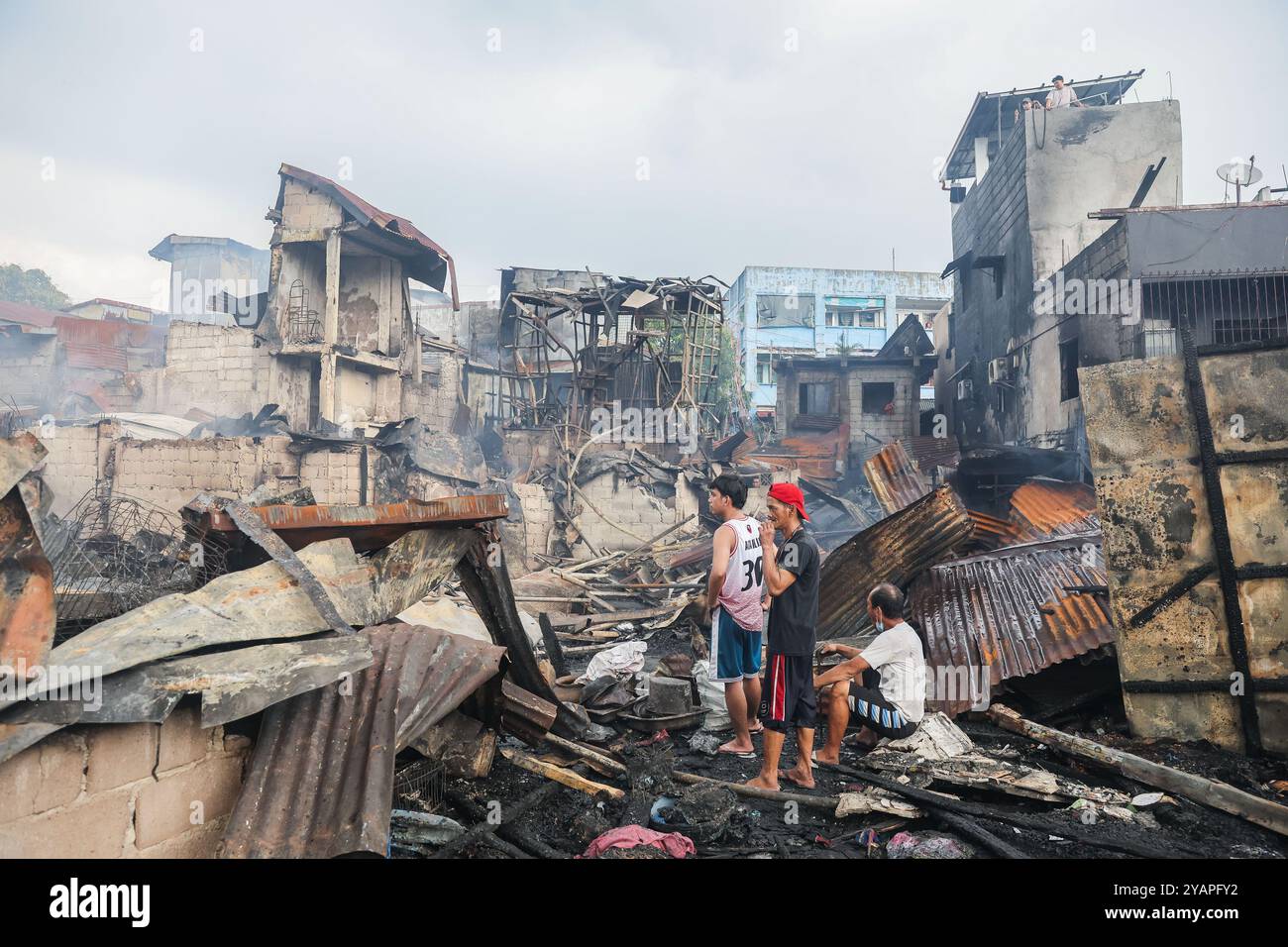 Manila, Filippine. 15 ottobre 2024. I residenti tornano nelle loro case carbonizzate dopo un incendio in una zona di slum a Manila, nelle Filippine, il 15 ottobre 2024. Crediti: Rouelle Umali/Xinhua/Alamy Live News Foto Stock