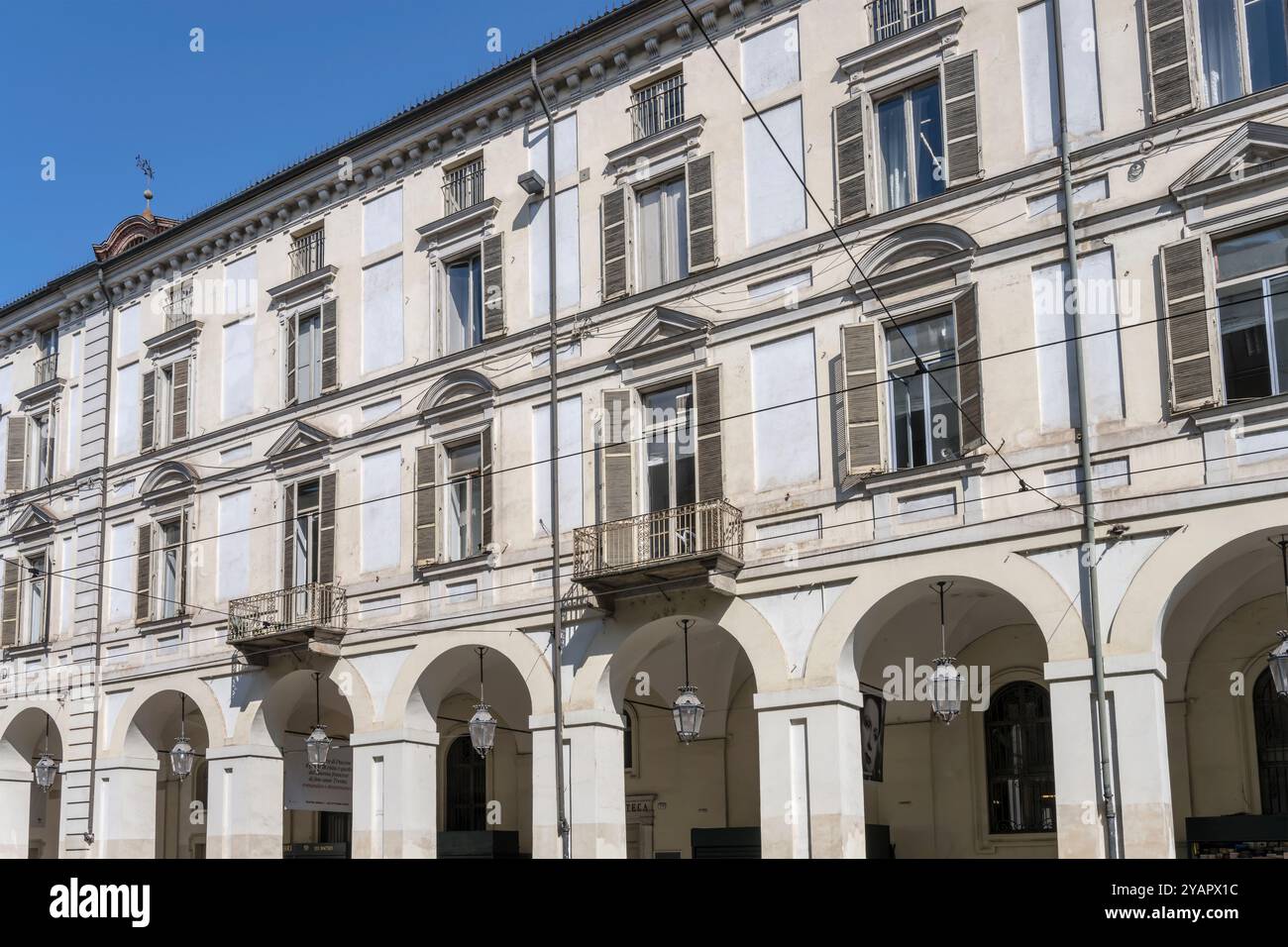 Paesaggio urbano con facciata e archi di un vecchio edificio in via po che non finisce mai con passaggi coperti, girato in piena luce a Torino, Italia Foto Stock