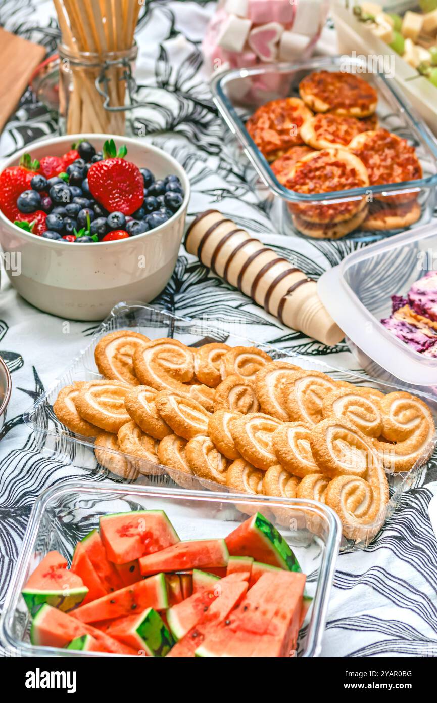 Picnic con vari stuzzichini, pane, pomodori, melone, verticale Foto Stock