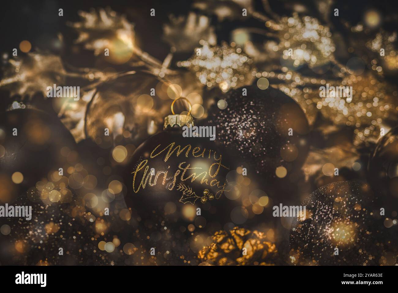 Bauble nero con testo buon Natale, bauble nero e oro e altre decorazioni natalizie. Foto Stock