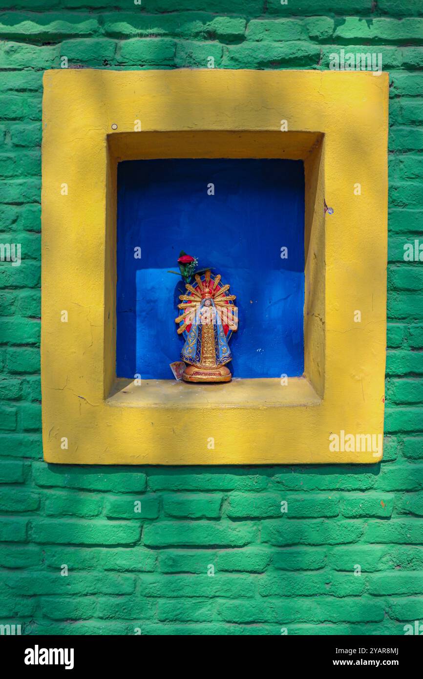 Vergine di Lujan in una finestra chiusa di cemento con fondo blu e mattoni esposti a la Boca Foto Stock