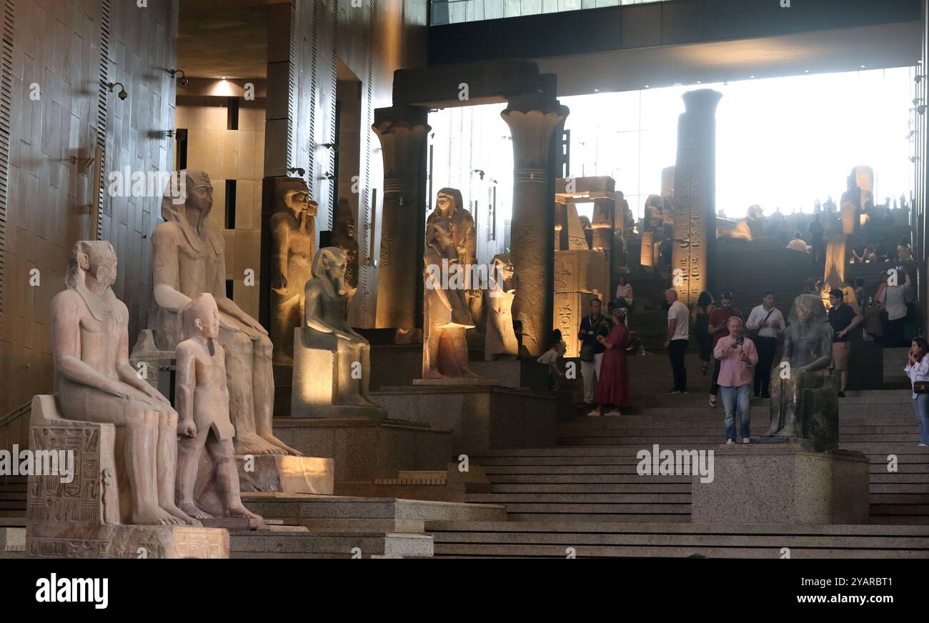 Le operazioni di prova presso il Grand Egyptian Museum in Egitto i visitatori passeranno davanti alle statue colossali dell'antico Egitto presso il Grand Egyptian Museum di Giza, Egitto, il 15 ottobre 2024. Il Grand Egyptian Museum ha annunciato le operazioni di prova delle gallerie principali, a partire dall'offrire ai visitatori un'anteprima esclusiva di dodici sale espositive accuratamente curate. Il Grand Egyptian Museum GEM, situato vicino alle piramidi di Giza, è il più grande museo archeologico del mondo dedicato a una singola civiltà, che espone circa 100.000 manufatti, tra cui la collezione completa dei tesori del re Tutankhamon. Designa Foto Stock