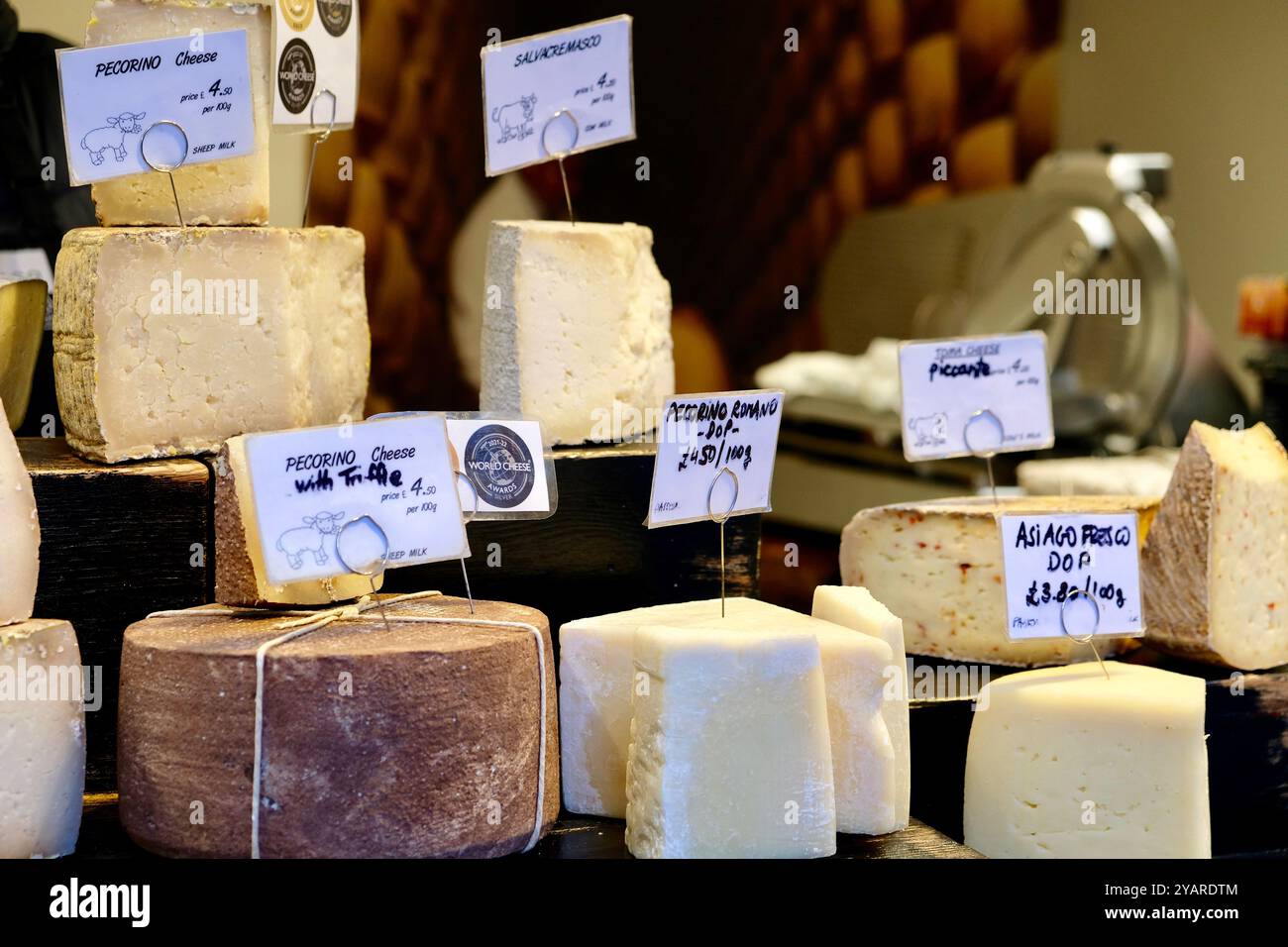 Formaggio italiano in vendita in mostra davanti a un banco di formaggi nel Borough Market, Londra. Foto Stock