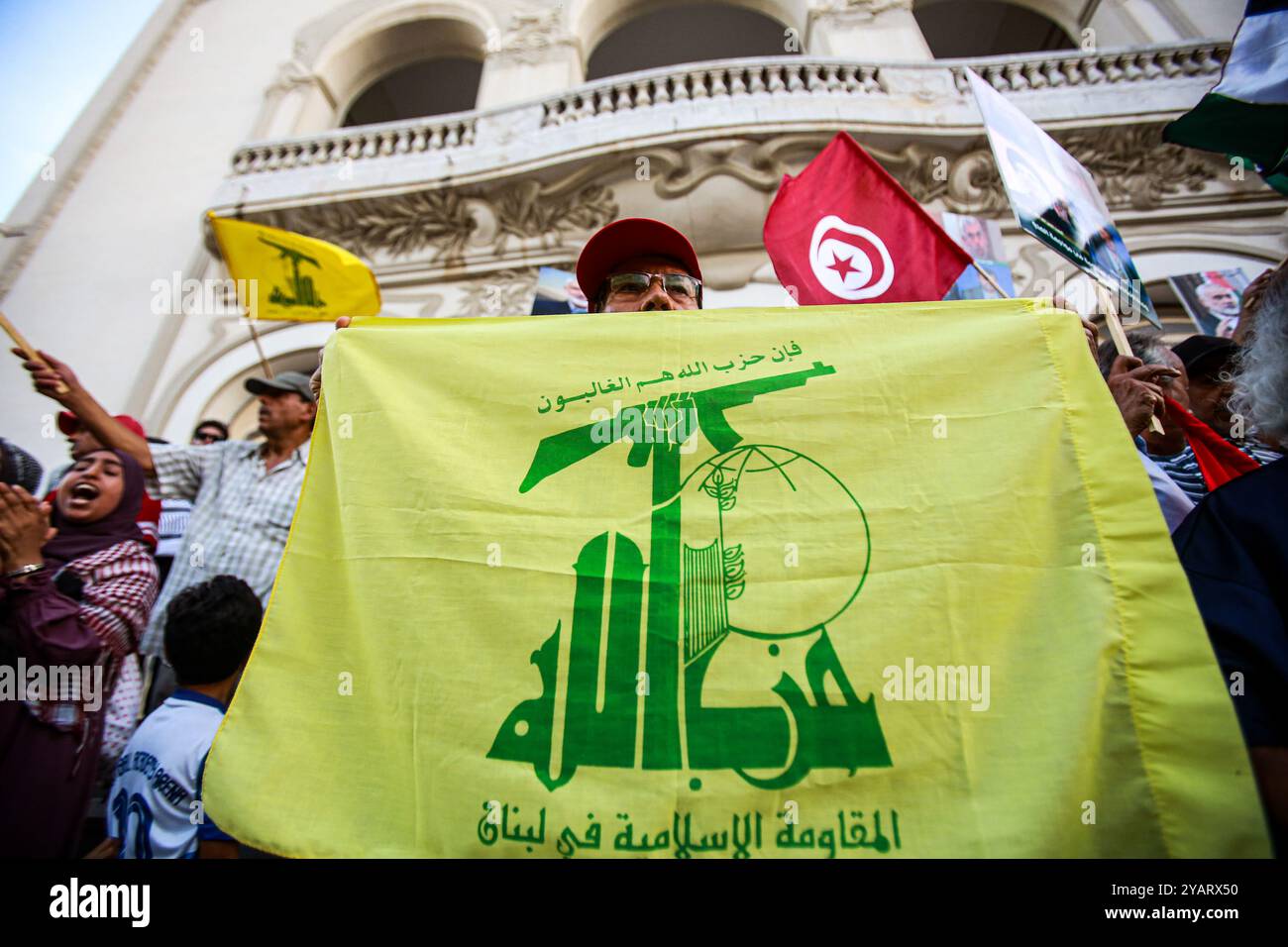 Tunisi, Tunisia. 15 ottobre 2024. Tunisi, Tunisia. 15 ottobre 2024. Un manifestante detiene una bandiera di Hezbollah durante una manifestazione a Tunisi a sostegno del popolo palestinese e libanese, tra le continue offensive militari israeliane a Gaza e in Libano e i continui attacchi in Cisgiordania. I partecipanti hanno sventolato le bandiere palestinesi, libanesi, mentre bruciavano la bandiera israeliana (Credit Image: © Hasan mrad/IMAGESLIVE via ZUMA Press Wire) SOLO USO EDITORIALE! Non per USO commerciale! Foto Stock
