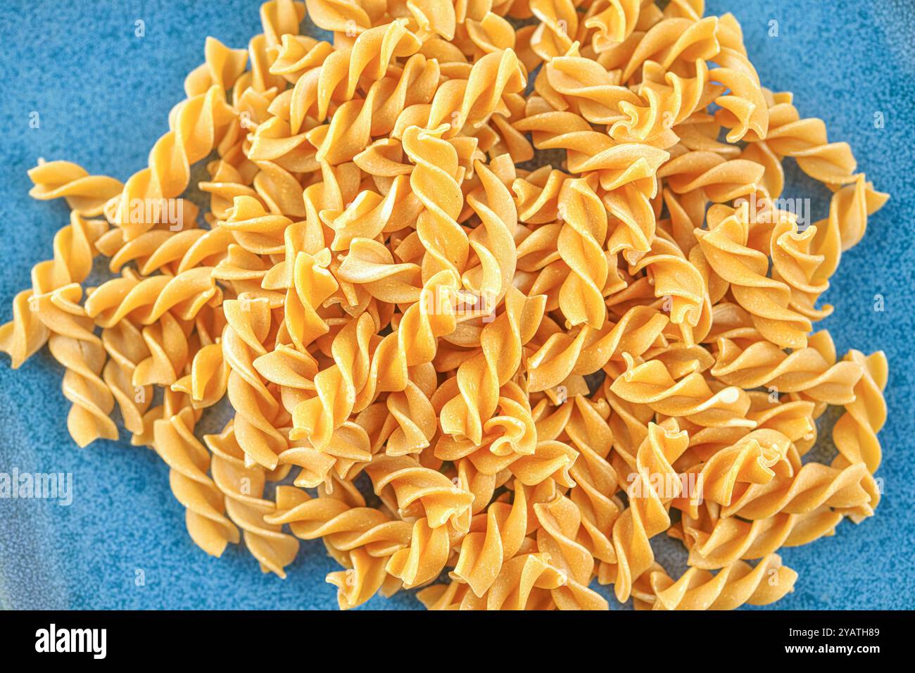 Primo piano di pasta cruda su un piatto blu. Foto Stock