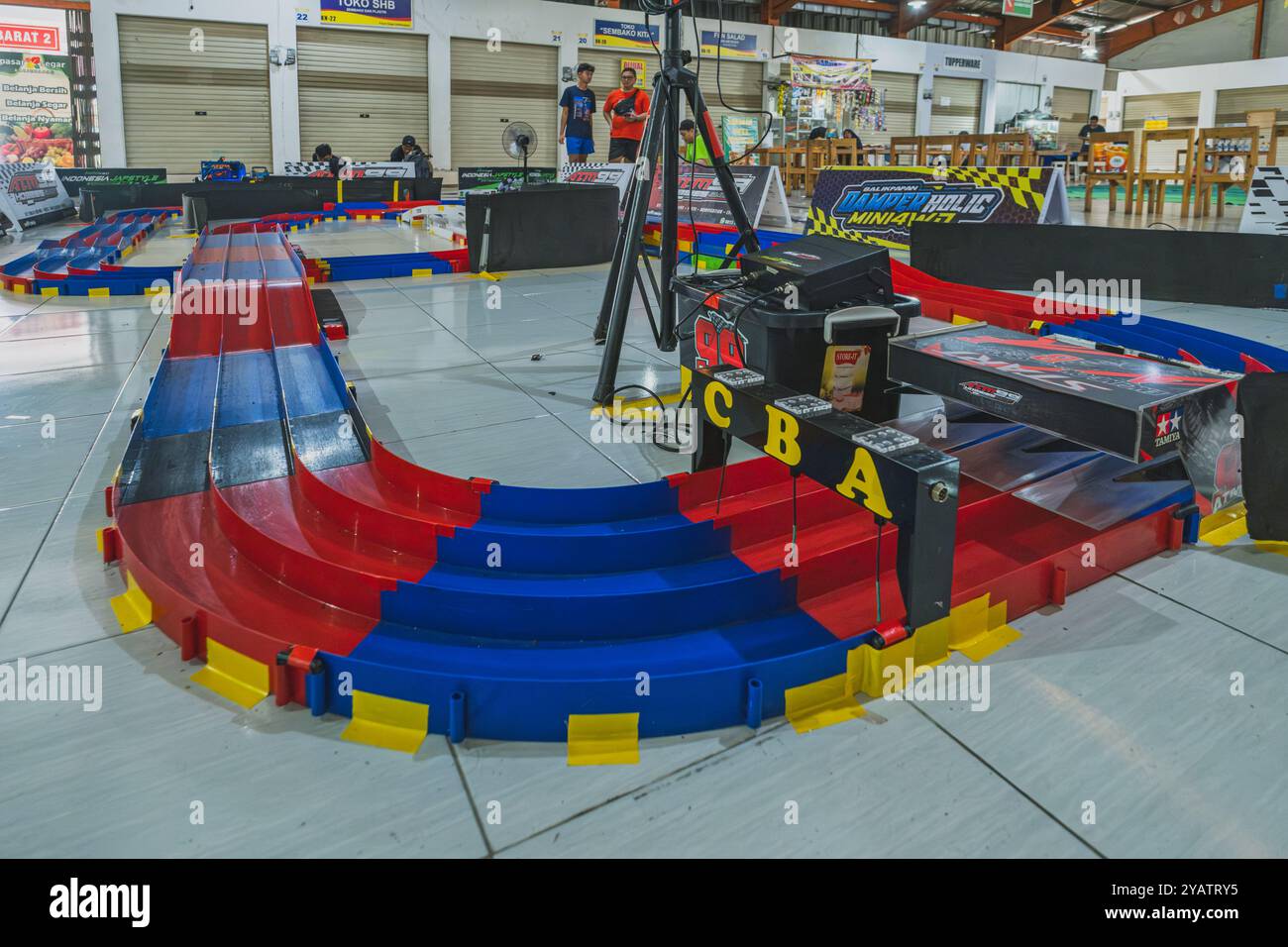 Balikpapan, Indonesia - 10 agosto 2024. Una vista ravvicinata del colorato circuito automobilistico Racing Mini 4WD al coperto caratterizzato da rosso, blu e giallo Foto Stock