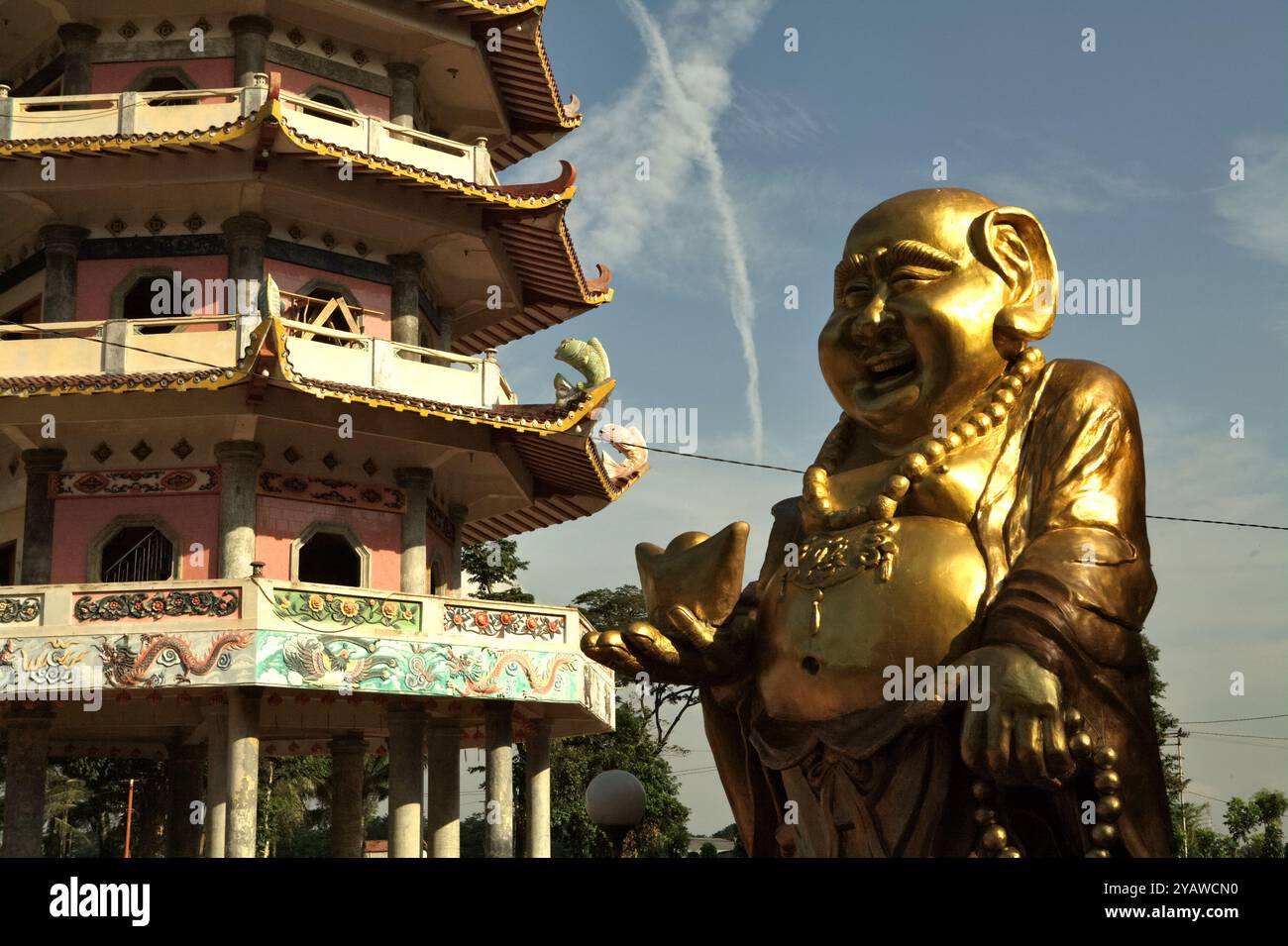 Statua del Buddha ridendo sullo sfondo della pagoda nel complesso del tempio Pulo Kemaro a Palembang, Sumatra meridionale, Indonesia. Foto Stock