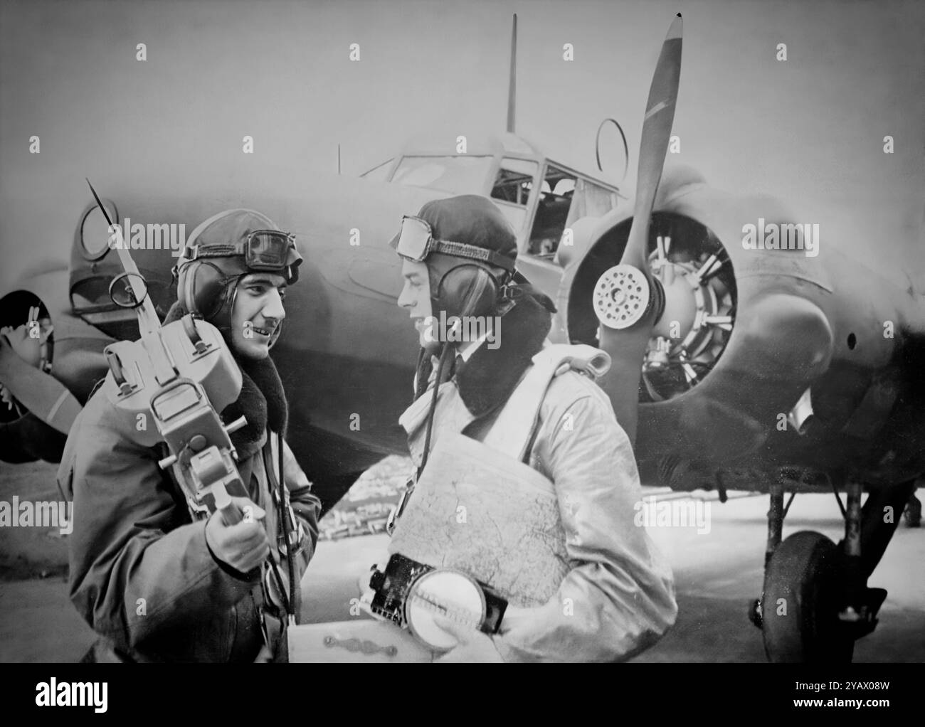 Gli equipaggi di volo con un Avro Anson (chiamato dopo l'ammiraglio inglese George Anson) un britannico bimotore, multi-ruolo di aeromobili che servita con la Royal Air Force (RAF) e Fleet Air Arm (FAA) durante la Seconda Guerra Mondiale. Essa è stata sviluppata durante il mid-1930s in risposta ad una richiesta di offerte emesse dalla British Air Ministero per una ricognizione marittima di aeromobili. Utilizzato inizialmente per la ricognizione marittima il funzionamento a fianco di grandi imbarcazioni battenti fu presto scoperto sono diventati obsoleti in prima linea per combattere i ruoli e mettere da utilizzare come un plurimotore trainer equipaggi. Foto Stock