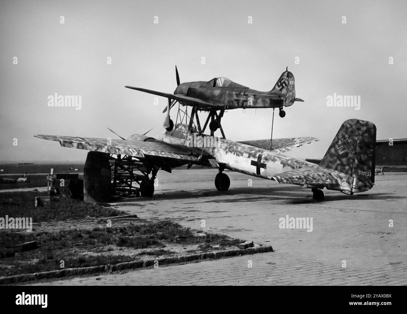 Il Mistel era una configurazione aeronautica composita sviluppata in Germania durante le ultime fasi della seconda guerra mondiale. Comprendeva un piccolo aereo di controllo pilotato montato sopra un grande drone che trasportava esplosivi, il Mistel. Il più riuscito utilizzò un bombardiere Junkers Ju 88 modificato come Mistel, con l'intero vano dell'equipaggio posizionato sul naso sostituito da un naso appositamente progettato riempito con un grande carico di esplosivi, formato in una carica sagomata. Il componente superiore è un Focke-Wulf FW 190. Circa 250 Mistel di varie combinazioni furono costruiti durante la guerra, ma incontrarono un successo limitato. Foto Stock