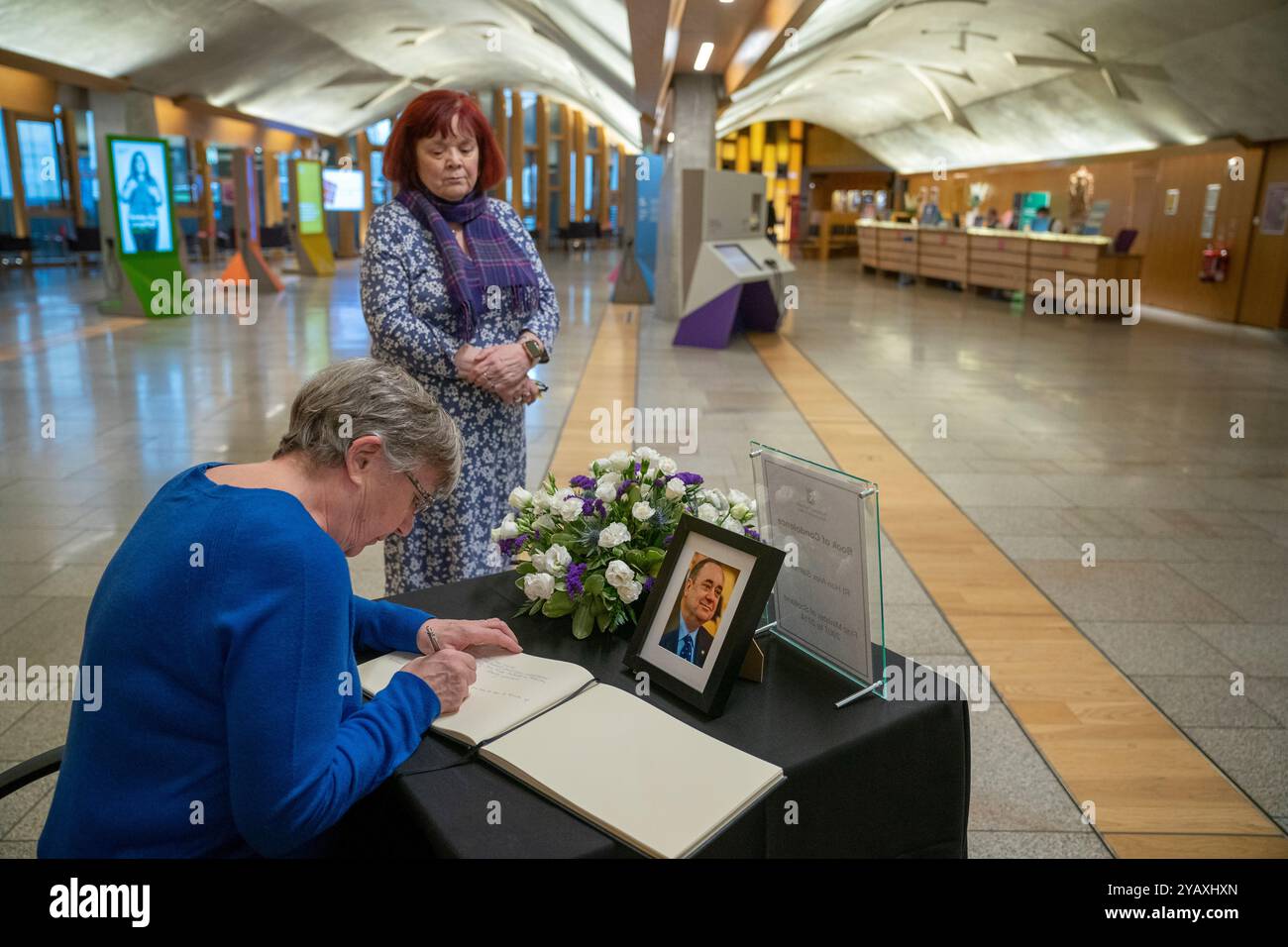 Un membro del pubblico firma un libro di condoglianze in memoria di Alex Salmond, al Parlamento scozzese di Edimburgo. L'ex primo ministro scozzese e attuale leader del Partito Alba è morto all'età di 69 anni sabato 12 ottobre 2024. Data foto: Mercoledì 16 ottobre 2024. Foto Stock