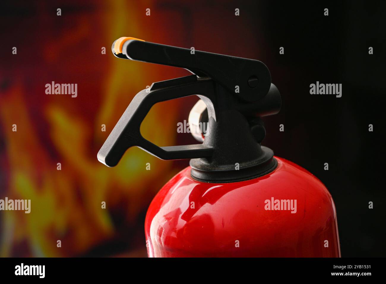 L'estintore rosso è pronto a combattere un incendio, simboleggiando la sicurezza e la preparazione. Foto Stock