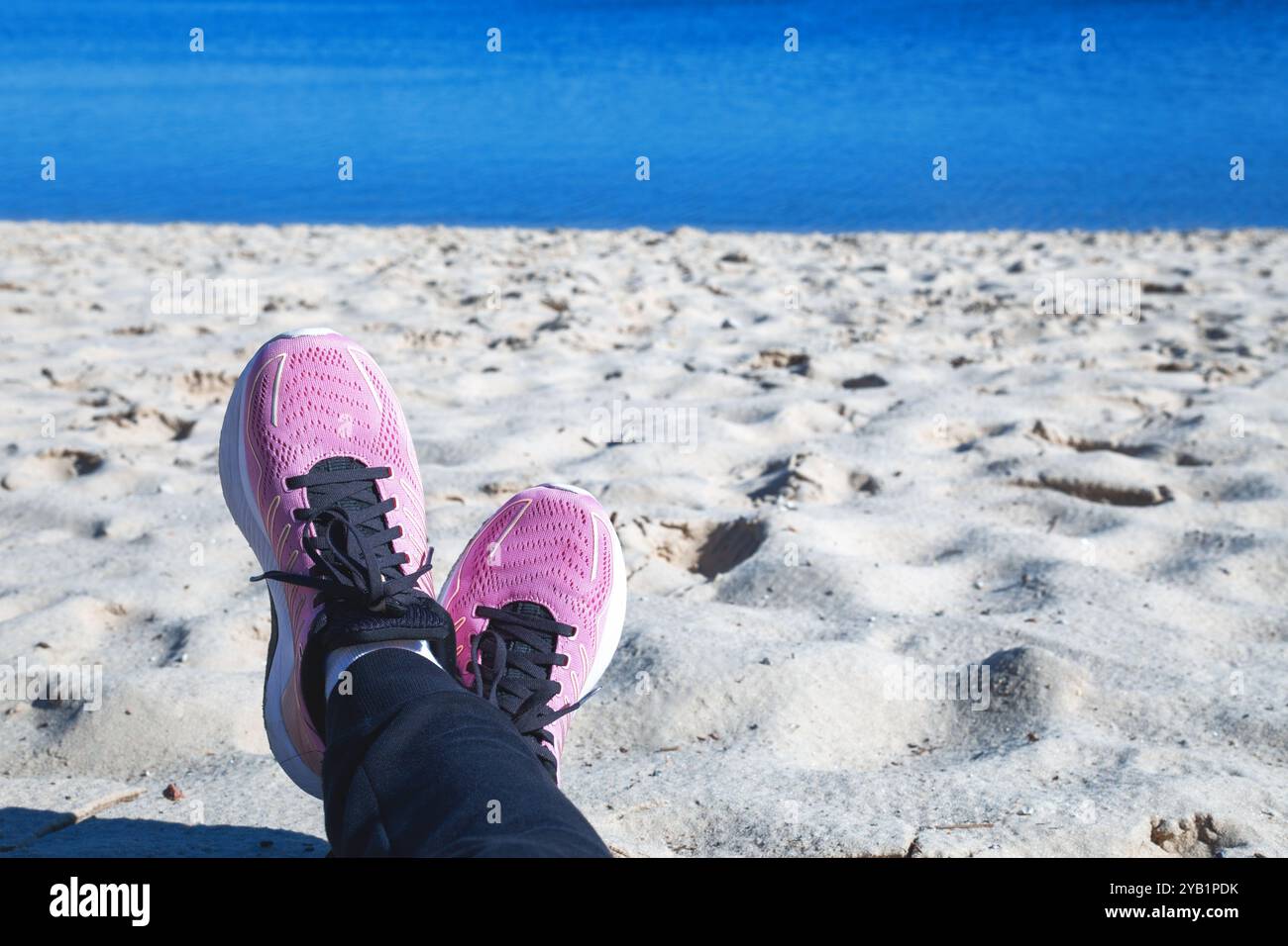 il turista in scarpe da ginnastica si rilassa sulla spiaggia Foto Stock