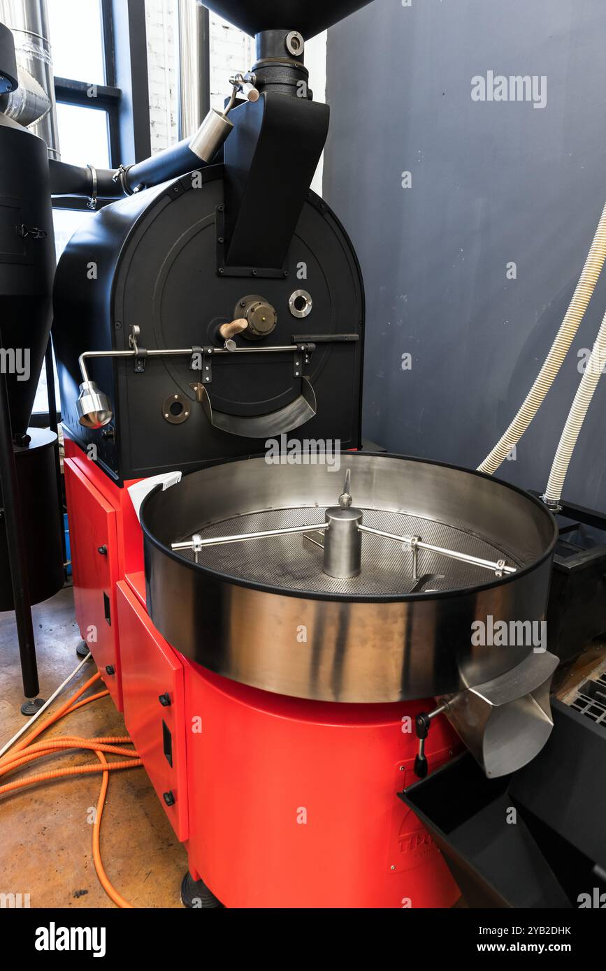 La torrefazione del caffè si trova in una caffetteria, foto verticale di apparecchiature per torrefazione industriali, un tamburo di raffreddamento vuoto Foto Stock