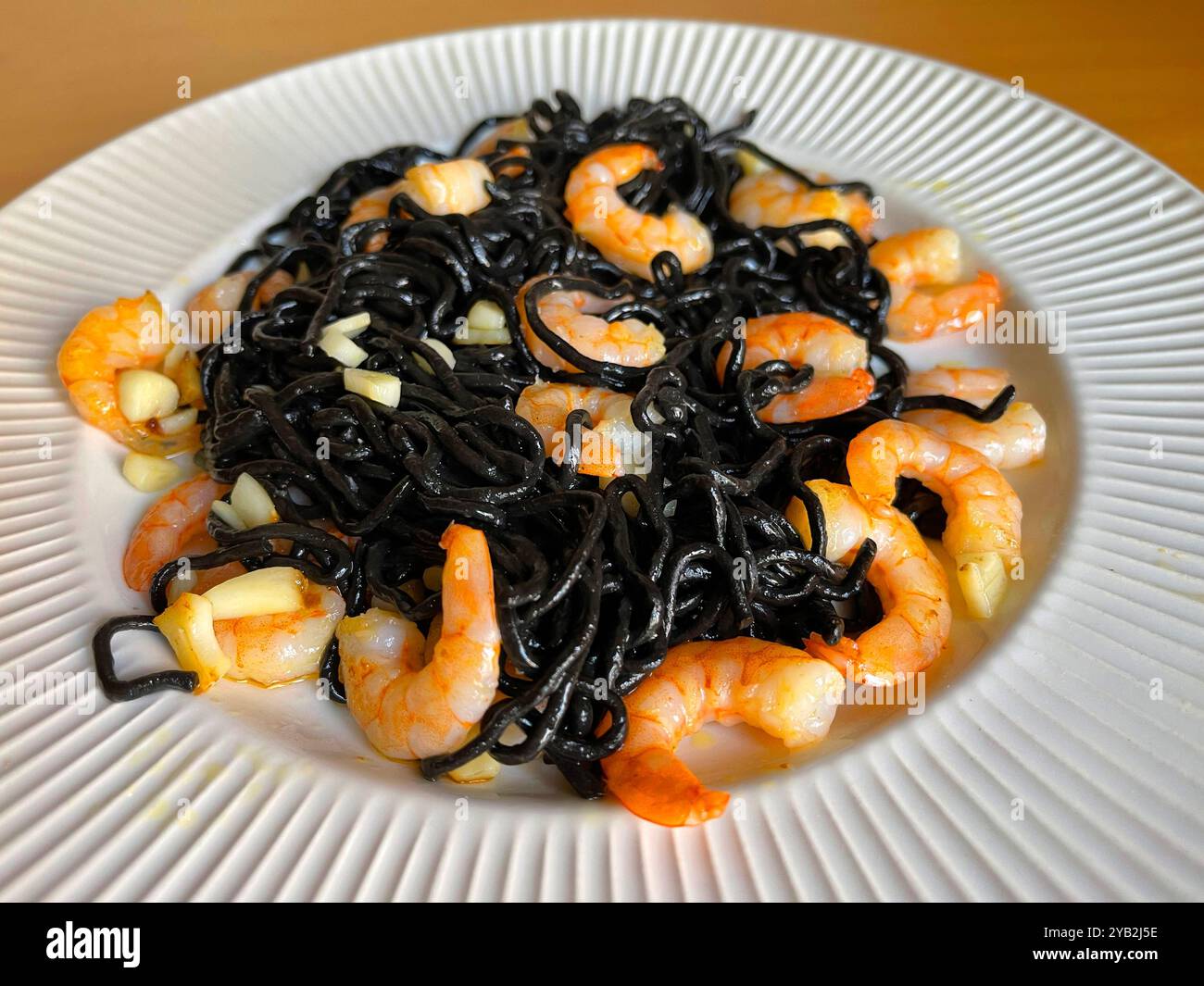 Spaghetti al nero con gamberi e aglio. - Immagine stock catturata con smartphone