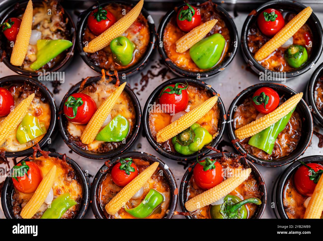 Gratin di patate al forno con pomodoro, paprika e mais. Foto Stock