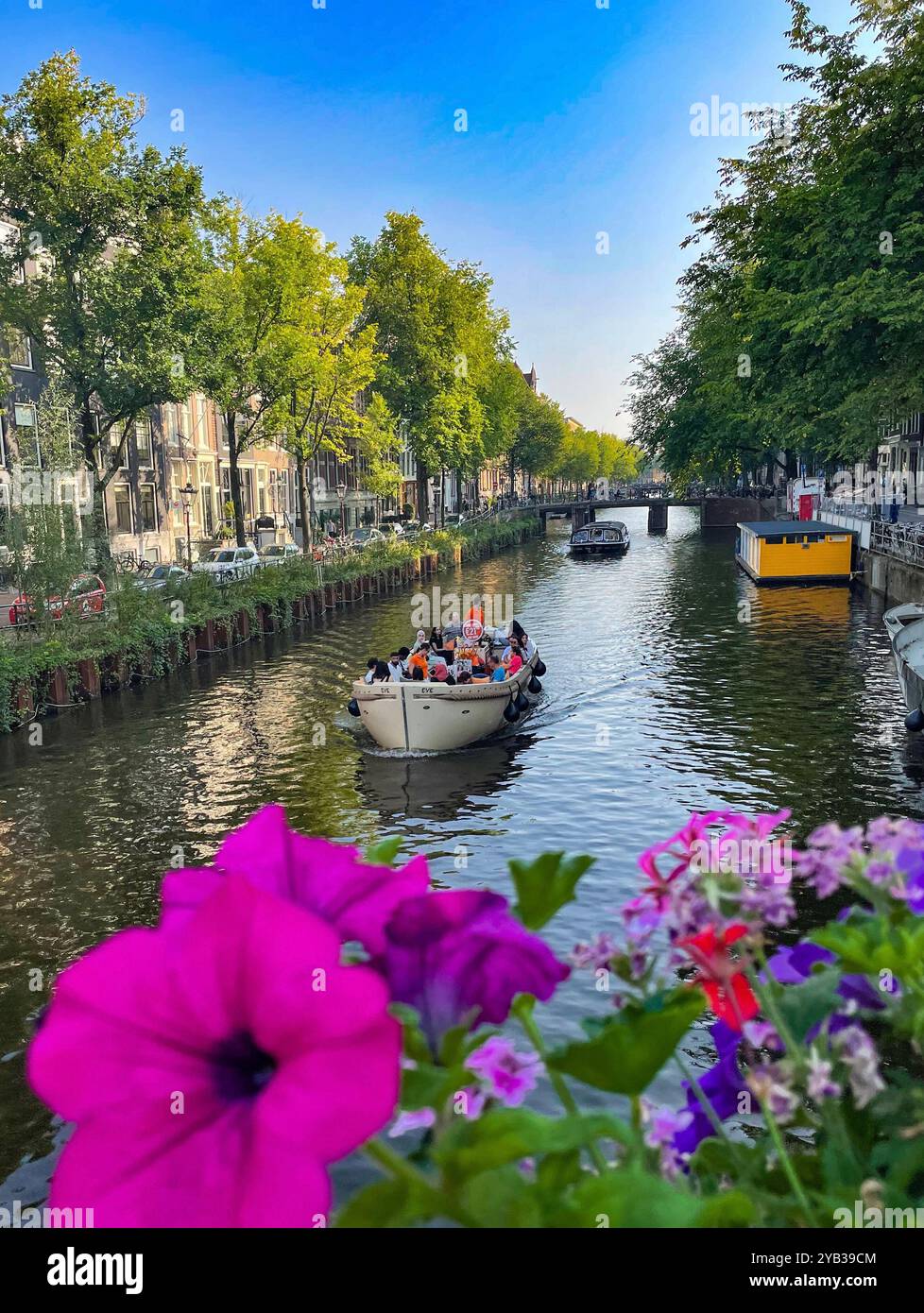 Barca sul canale di Amsterdam con fiori in primo piano Foto Stock