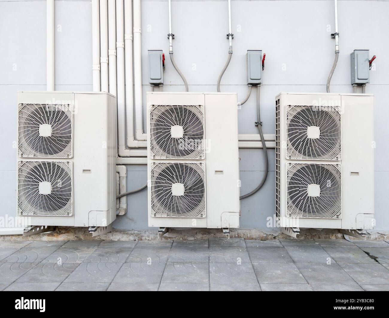 L'unità compressore dell'impianto di climatizzazione è appesa alla parete bianca dietro la stazione della monorotaia urbana, vista frontale con lo spazio di copia. Foto Stock