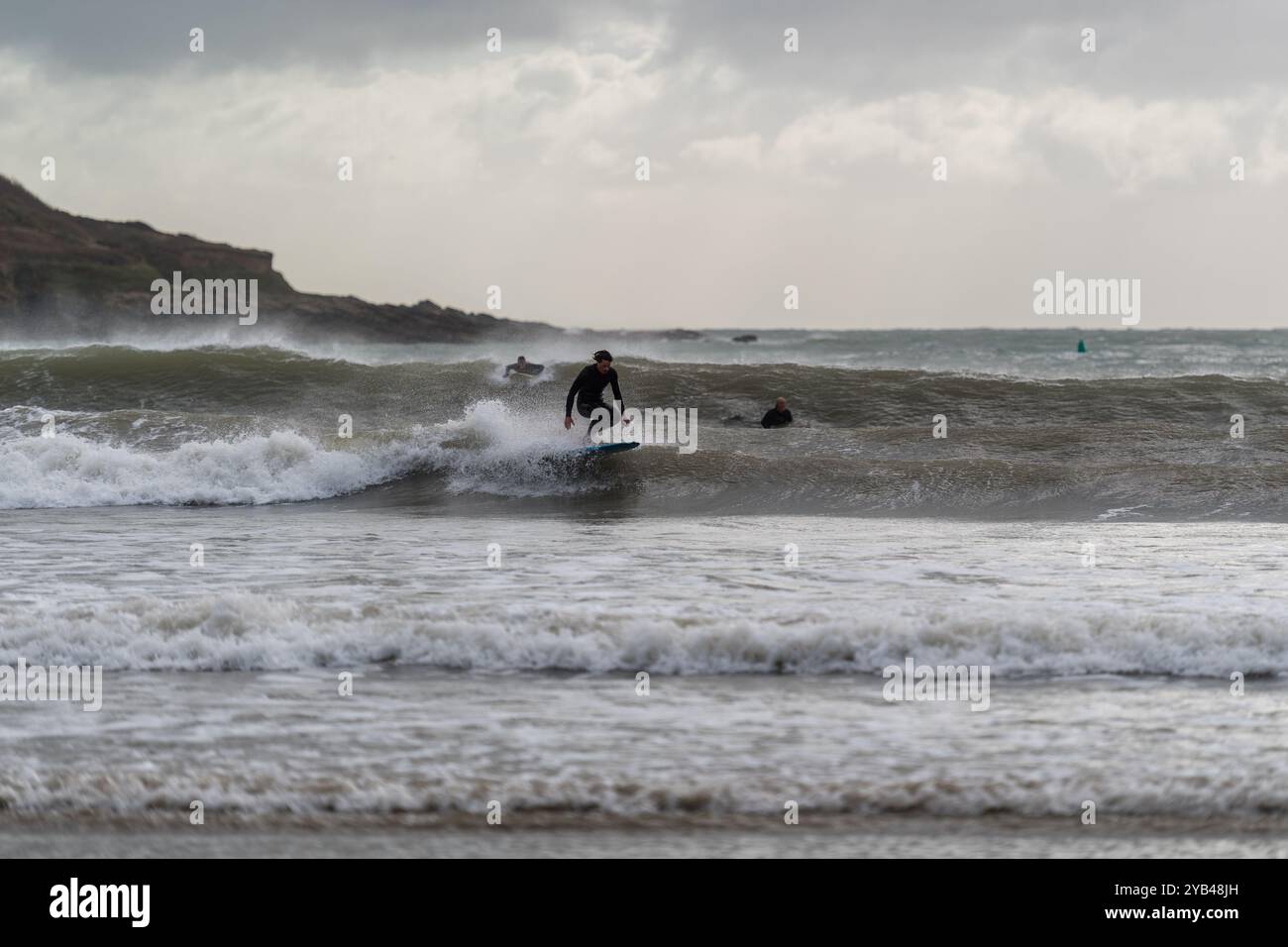 I surfisti sfruttano al massimo la tempesta Brian, catturando le onde che arrivano su North Sands a Salcombe, South Hams, Devon, indossando westuits per le stagioni autunnali. Foto Stock