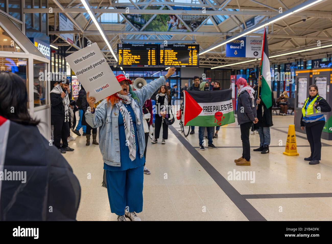 Leeds, Regno Unito. 16 OTTOBRE 2024. Il manifestante palestinese ha un segnale poco prima dell'incidente in cui un uomo è dirompente e presumibilmente assalto a favore del protestatore palestinese, portando a parlare con entrambi gli uomini dalla polizia. Non ci sono stati arresti. Questo avviene quando i manifestanti palestinesi hanno organizzato una dimostrazione all'interno della stazione degli autobus di Leeds in seguito alla protesta fuori dagli uffici della BBC Yorkshire nel centro di Leeds accusandoli di pregiudizi nella copertura del conflitto di Gaza. Credito Milo Chandler/Alamy Live News Foto Stock