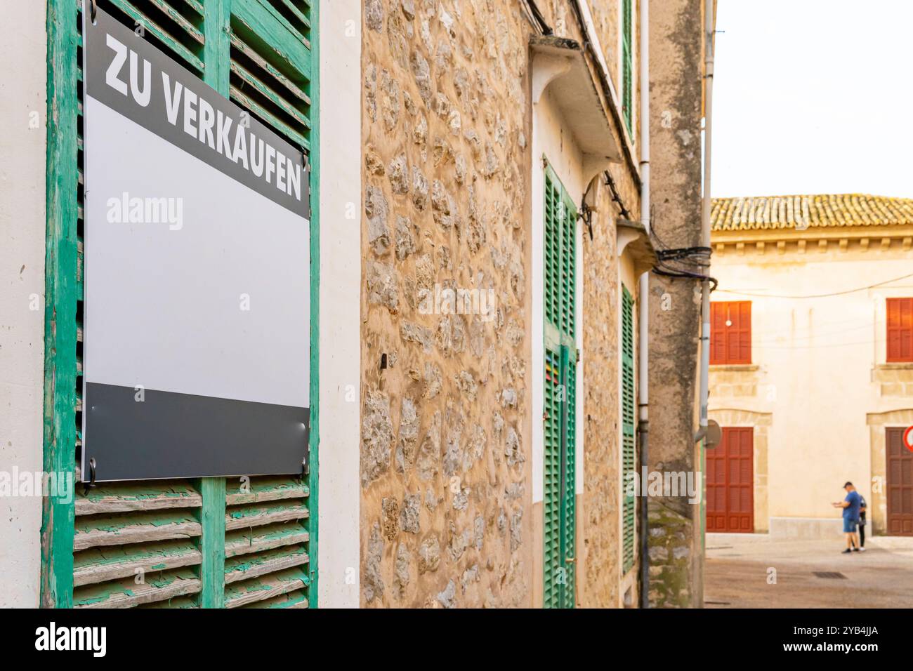 Cartello in vendita scritto in tedesco sulla facciata di un edificio storico sull'isola di Maiorca. Immagine della speculazione nel mercato immobiliare e nel Foto Stock