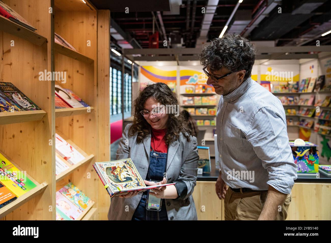 Francoforte, Germania. 16 ottobre 2024. La gente leggeva un libro alla 76a Fiera del libro di Francoforte a Francoforte, Germania, 16 ottobre 2024. La Fiera del Libro di Francoforte è stata inaugurata ufficialmente martedì, mettendo in evidenza una varietà di generi e argomenti, tra cui la categoria "New Adult" - romanzi romantici rivolti ai giovani adulti - accanto alla letteratura per bambini e giovani adulti, ai fumetti, ai servizi di streaming e all'editoria educativa e accademica. Crediti: Zhang fan/Xinhua/Alamy Live News Foto Stock